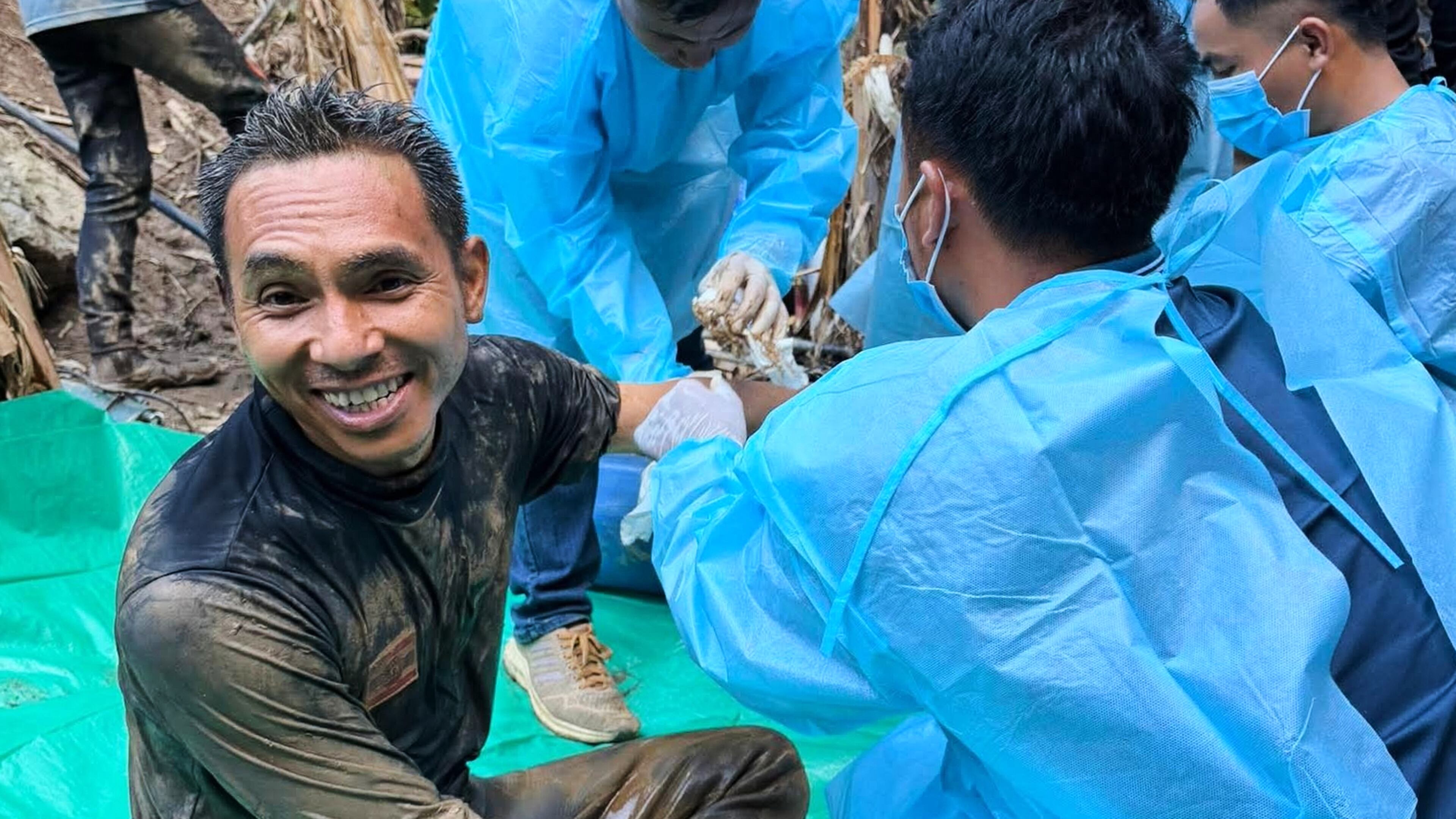 In this image released by Metta Tham Rescue Kalasin, rescuers, left, sit after rescuing people who have been trapped in a cave in Xaisomboun province, Laos. Wednesday, May 27, 2026. (Metta Tham Rescue Kalasin via AP)