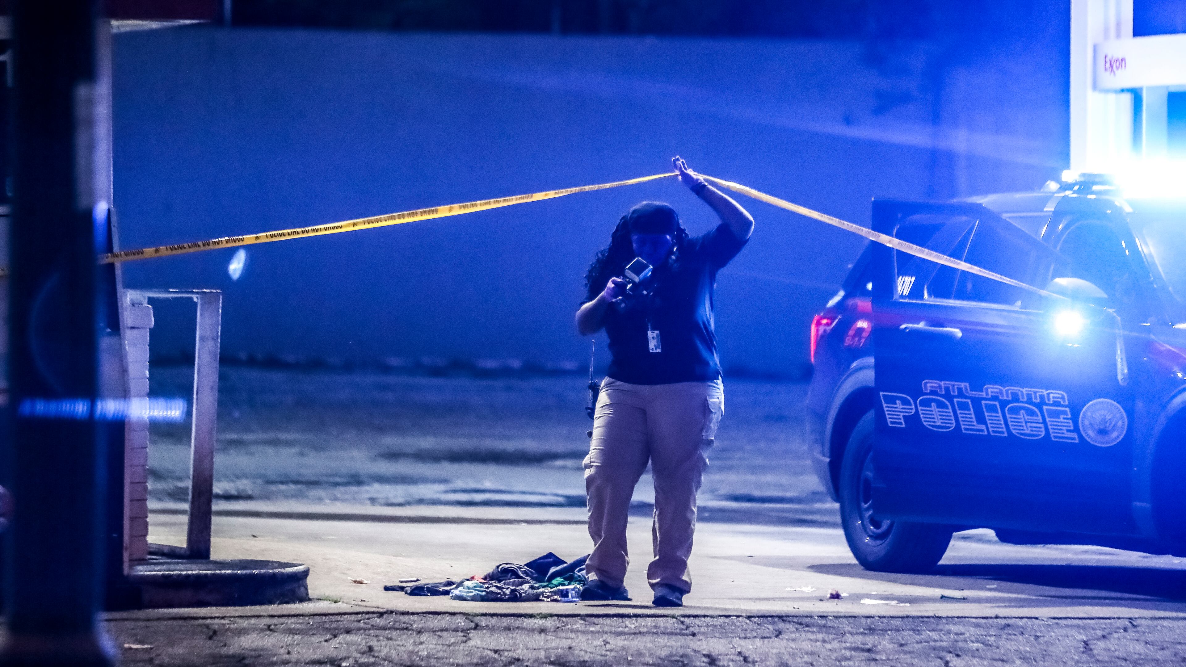 An Atlanta police crime scene technician investigates a shooting last month. (John Spink / John.Spink@ajc.com)
