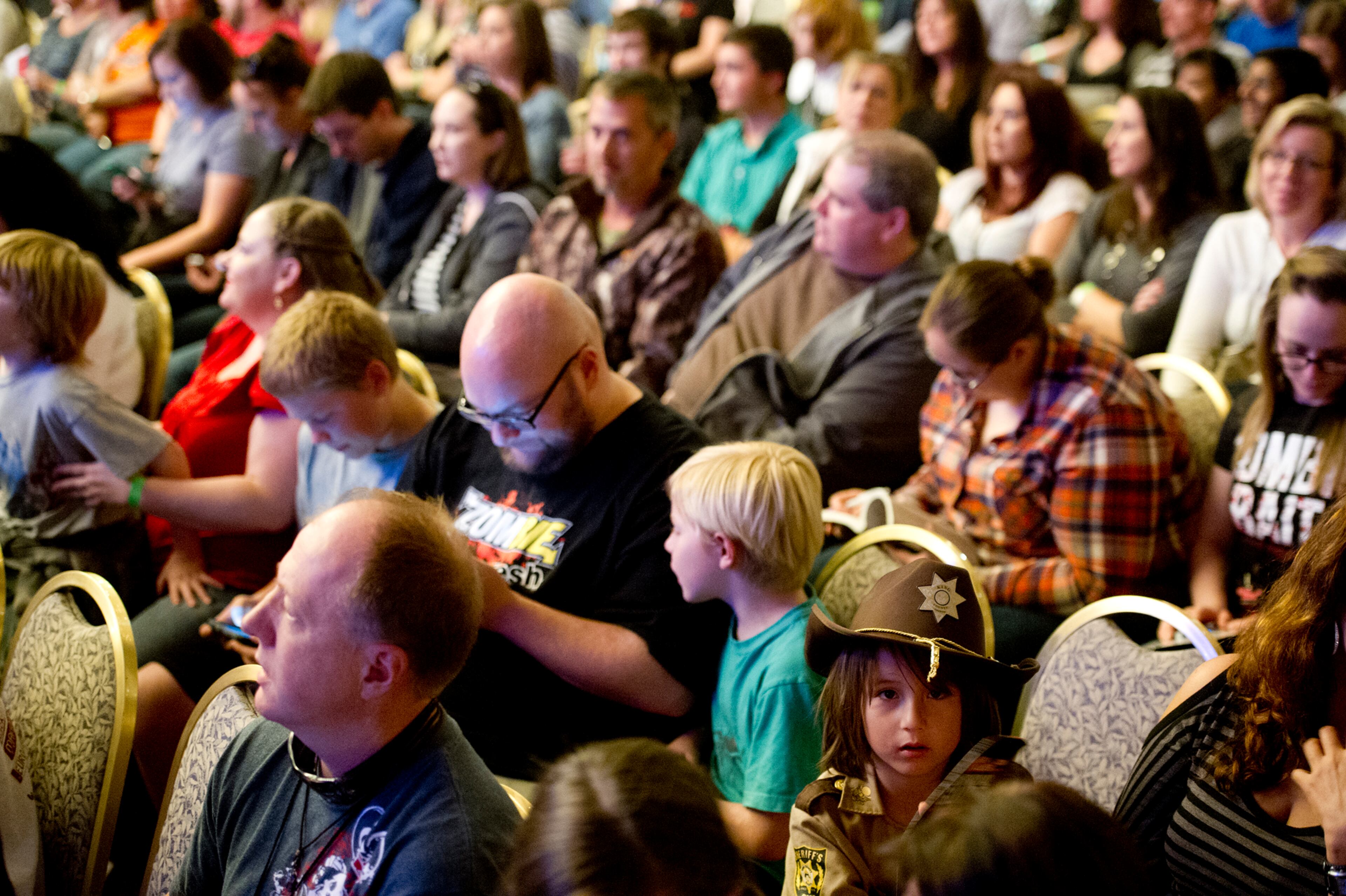 Dressed as Rick Grimes from the Walking Dead, Junior Martinez (bottom right) waits for Andrew Lincoln to come on stage during Walker Stalker Con at the Atlanta Convention Center at AmericasMart on Nov. 2, 2013.