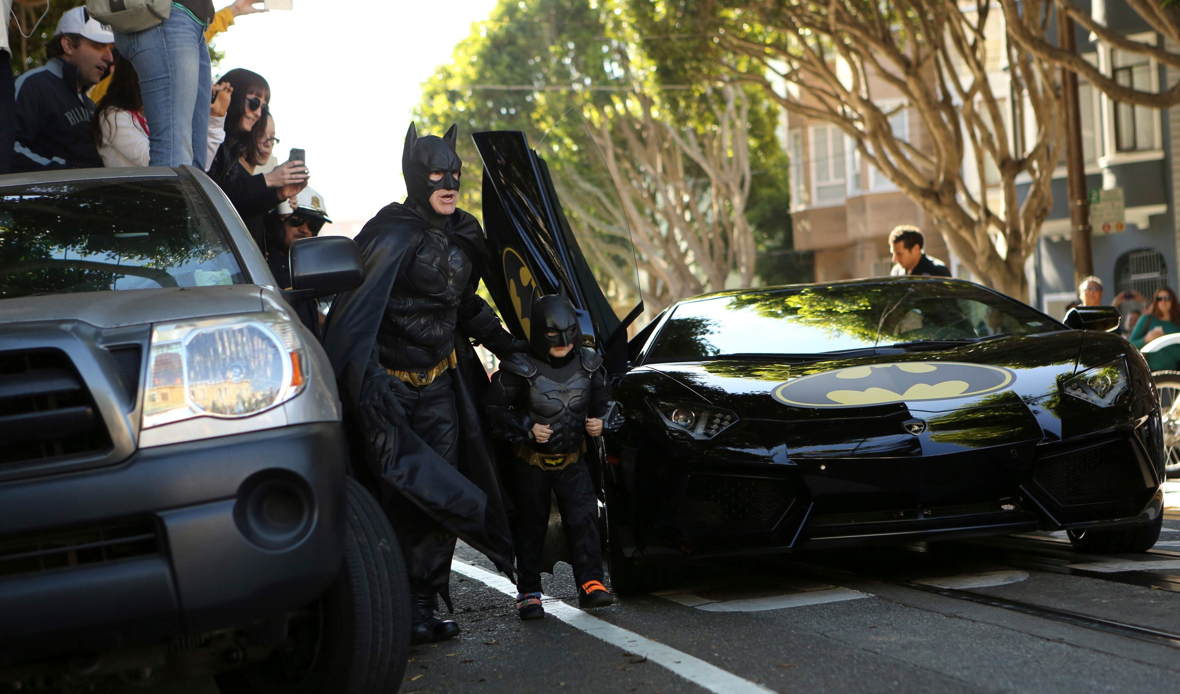 Five-year-old leukemia survivor Miles Scott dressed as "Batkid" arrives with a man dressed as Batman to rescue a woman in distress as part of a day arranged by the Make-A-Wish Foundation in San Francisco, California November 15, 2013. The young cancer survivor will be treated to various super hero scenarios including receiving a commendation at San Francisco City Hall.