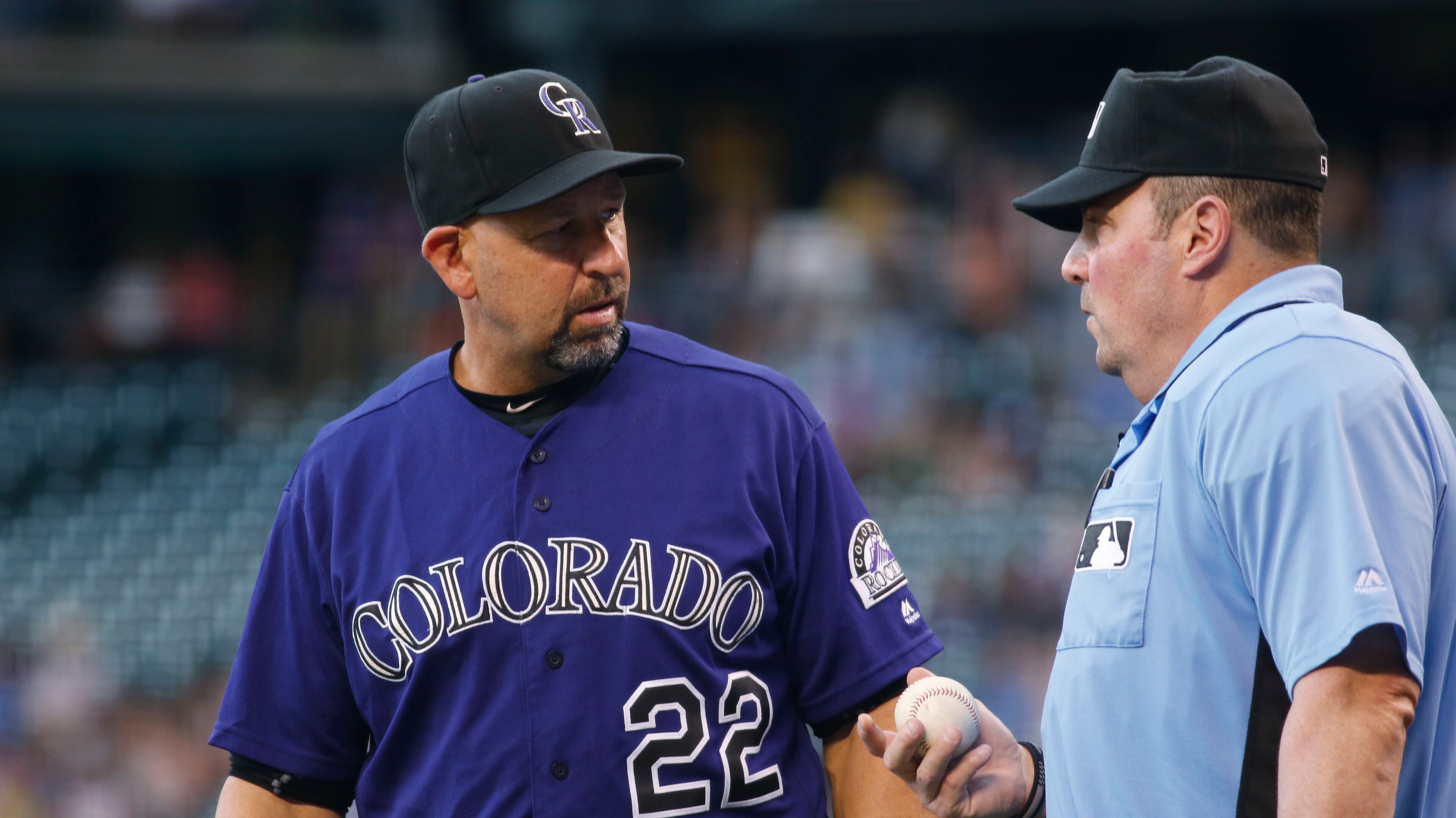 Colorado Rockies manager Walt Weiss, left, confers with home plate umpire Marty Foster after Rockies left fielder Ryan Raburn bobbled and then dropped a fly ball hit by Atlanta Braves' Freddie Freeman that was ruled a triple in the first inning of a baseball game Friday, July 22, 2016, in Denver. (AP Photo/David Zalubowski)