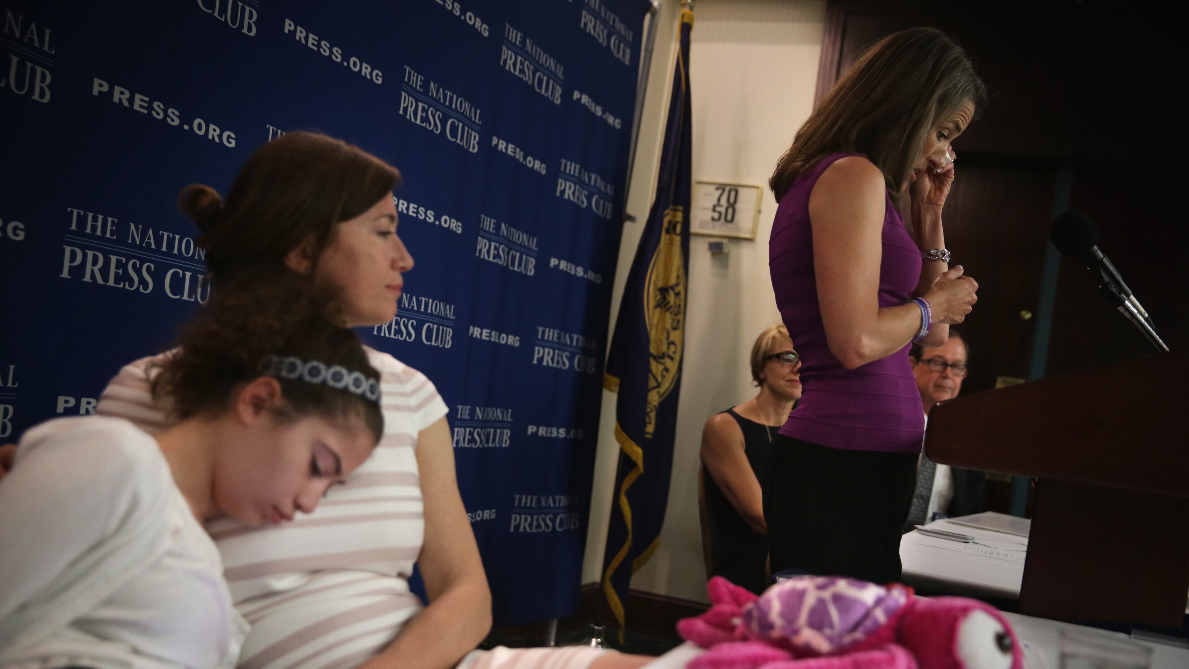 Liza Smith (R) of White Stone, Va., mother of 14-year-old Haley Smith (L) who suffers from a severe form of epilepsy called Dravet Syndrome, wipes tears as she speaks during a news conference about efforts to legalize therapeutic hemp and cannabidiol at the National Press Club April 22 in Washington. (Alex Wong/Getty Images)