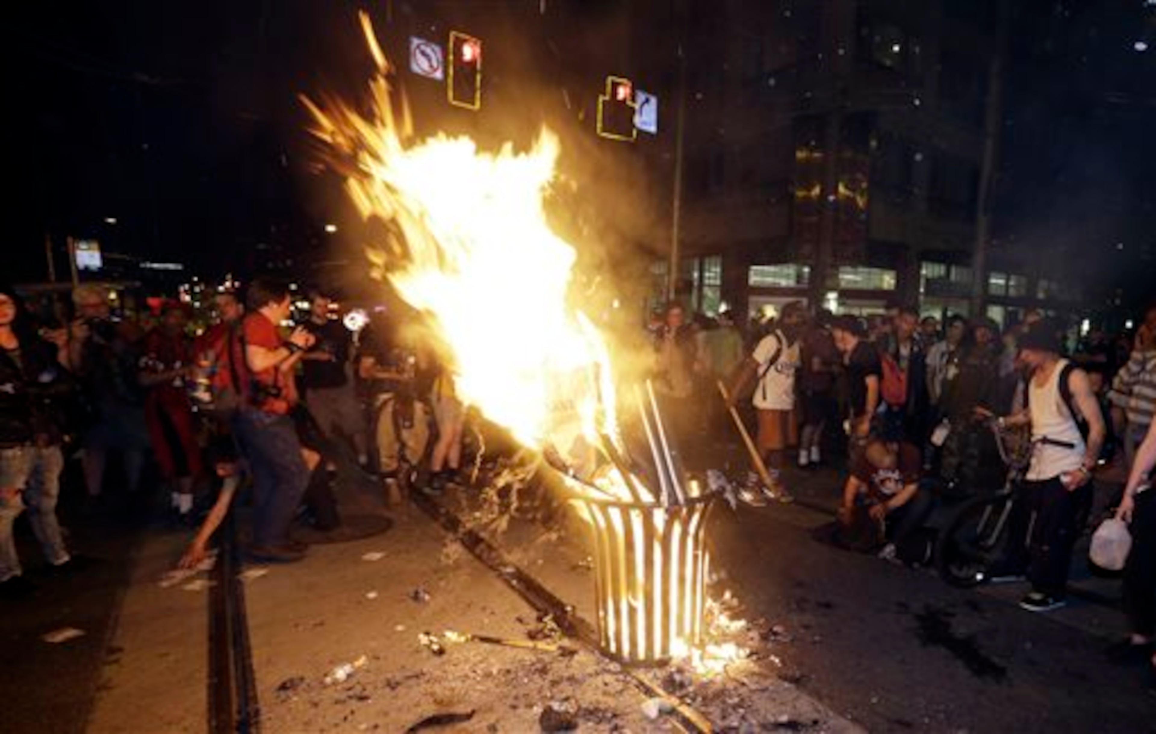 Protesters burn signs during May Day activities Thursday, May 1, 2014 in Seattle. Police have made several arrests and fired pepper spray as anti-capitalist marchers meandered through Seattle several hours after hundreds of peaceful demonstrators took part in a May Day march in support of immigrant rights and a boost in the minimum wage. (AP Photo/Ted S. Warren)