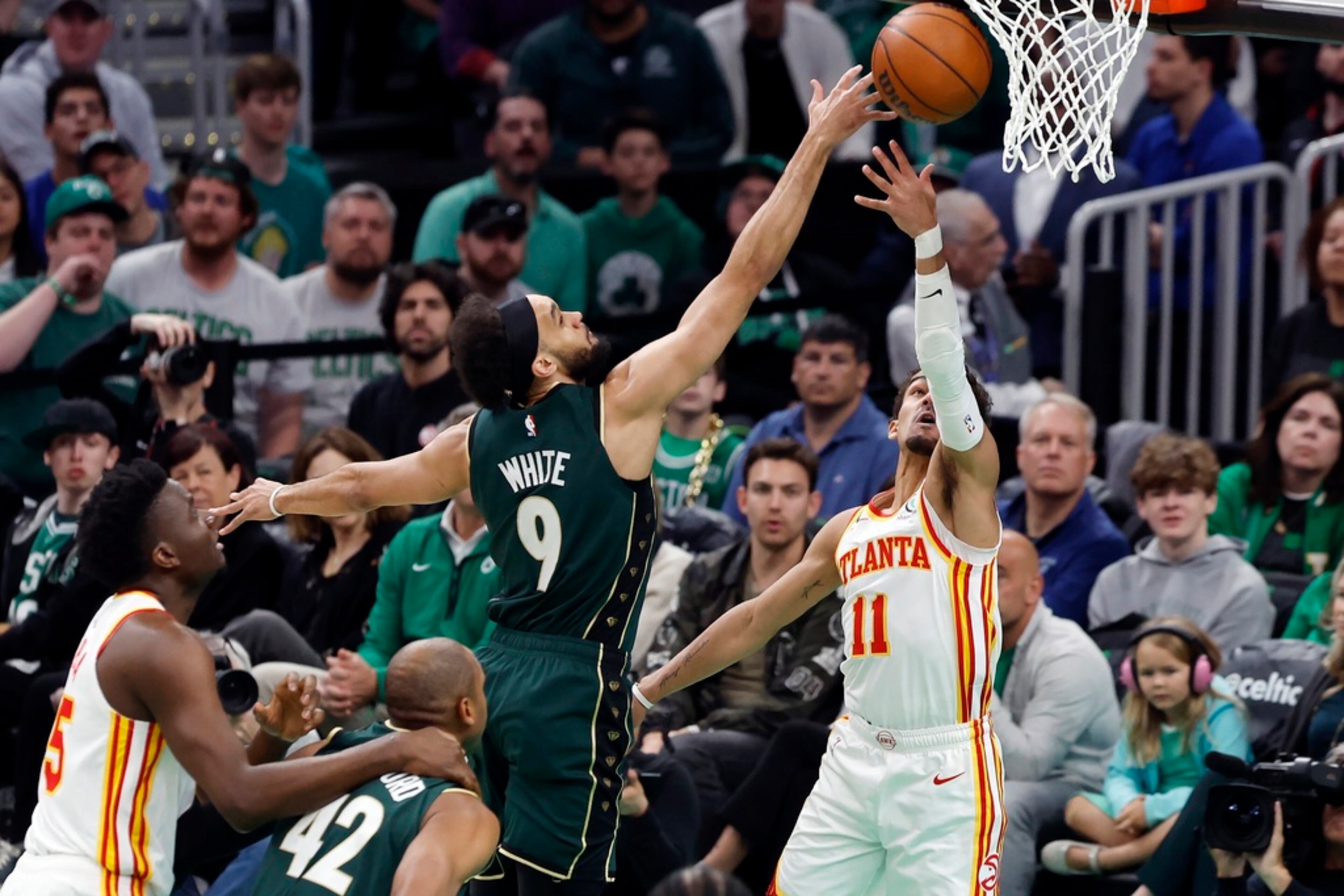 Boston Celtics' Derrick White (9) blocks a shot by Atlanta Hawks' Trae Young (11) in the first half during Game 1 in the first round of the NBA basketball playoffs, Saturday, April 15, 2023, in Boston. (AP Photo/Michael Dwyer)