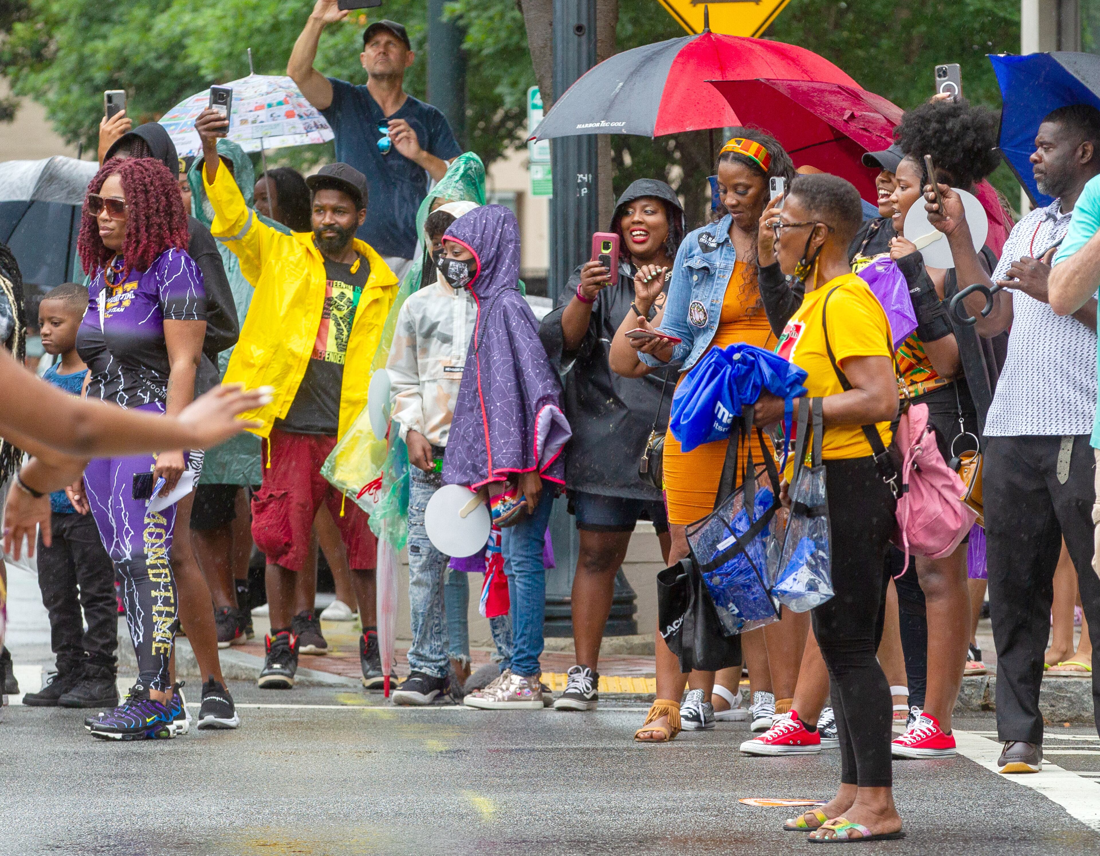 The crowd tries to stay dry as they cheer on the Juneteenth Atlanta Parade on Saturday, June 19, 2021. (Photo: Steve Schaefer for The Atlanta Journal-Constitution)
