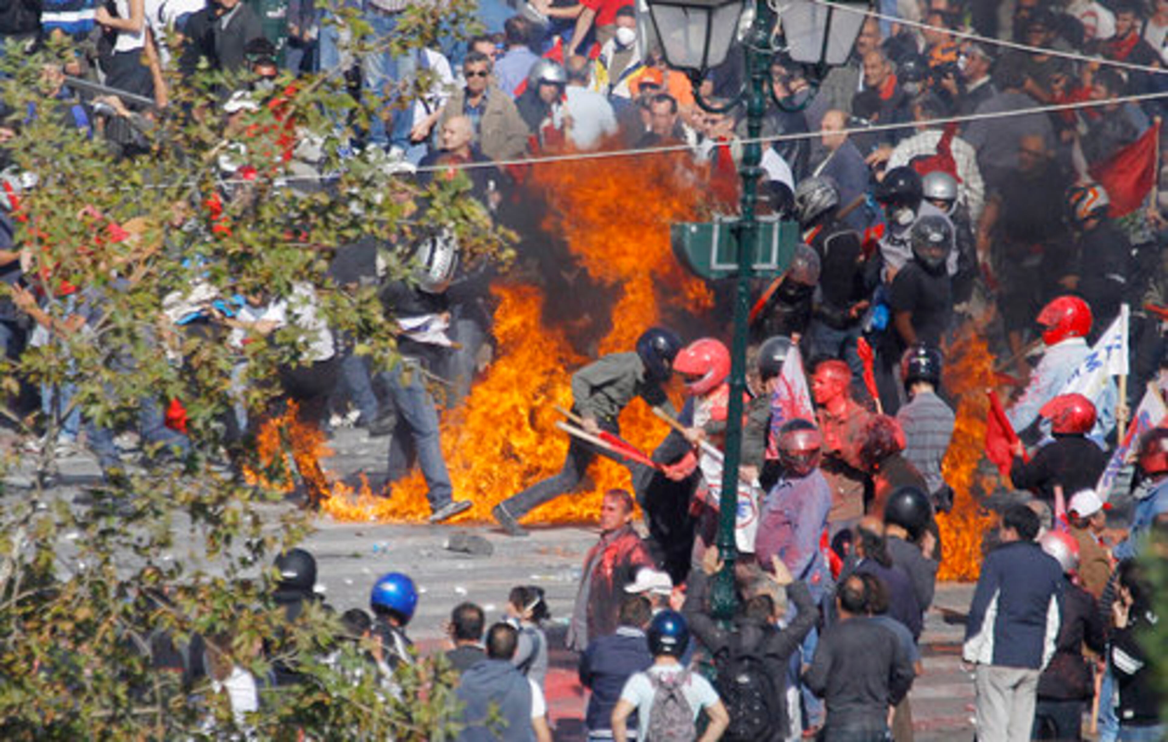 The rioting erupted when hundreds of masked anarchist youths attacked a peaceful rally of about 50,000 people outside parliament, pelting them with firebombs and jagged chunks of marble. The Communist-backed union members counterattacked, and chaos ensued as the two sides fought with sticks and rocks before riot police fired volleys of tear gas to separate them. Here, communist-backed union protesters run way from a fire bomb hurled at them by other demonstrators in Athens.