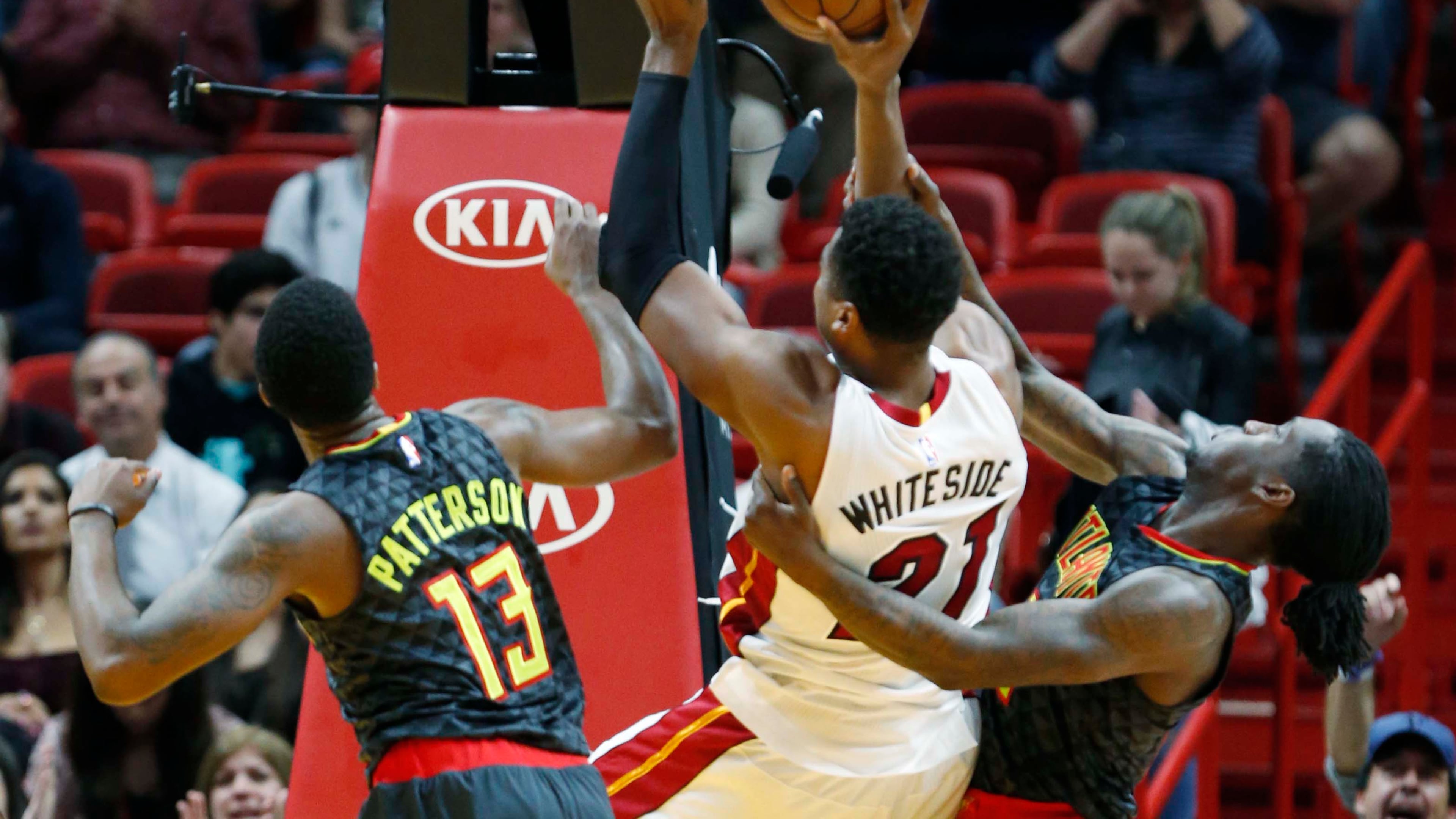 Atlanta Hawks forward Taurean Prince, right, pulls on Miami Heat center Hassan Whiteside (21) as Whiteside goes up for a shot against Prince and guard Lamar Patterson (13) during the second half of an NBA basketball game, Wednesday, Feb. 1, 2017, in Miami. Prince was ejected for pulling Whiteside down and was assessed a flagrant-2. James Johnson retaliated in Whiteside’s defense, and was ejected after getting a technical. The Heat defeated the Hawks 116-93. (AP Photo/Wilfredo Lee)