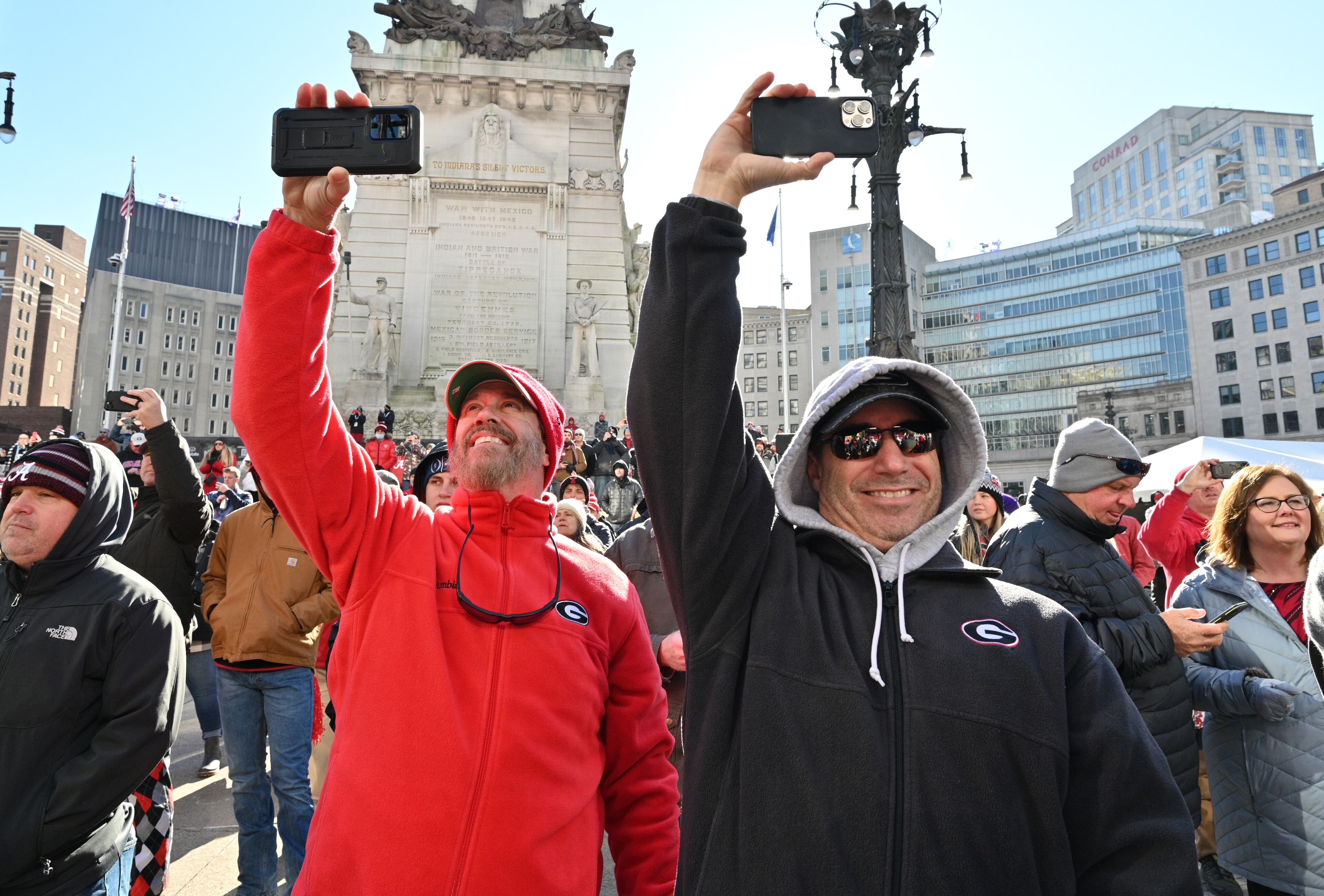 Georgia fans hold their smartphones to take photos as Georgia Redcoat Marching Band performs during Allstate Championship Tailgate event at Monument Circle prior to the 2022 College Football Playoff National Championship Game at Lucas Oil Stadium in Indianapolis on Monday, January 10, 2022. (Hyosub Shin / Hyosub.Shin@ajc.com)