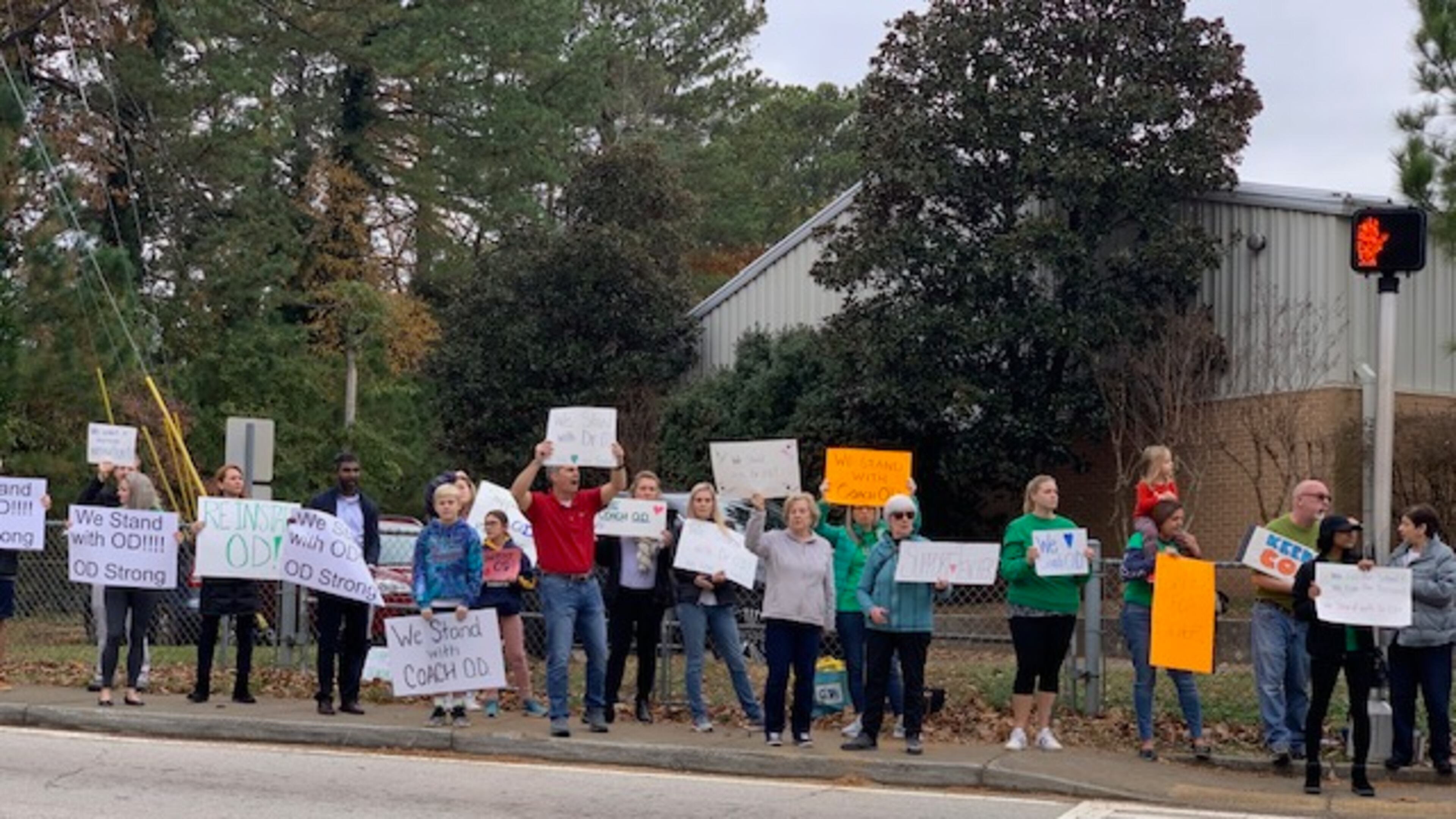 Several dozen parents and community members showed their support for suspended coach James O’Donnell Friday at Henderson Mill Elementary School.
