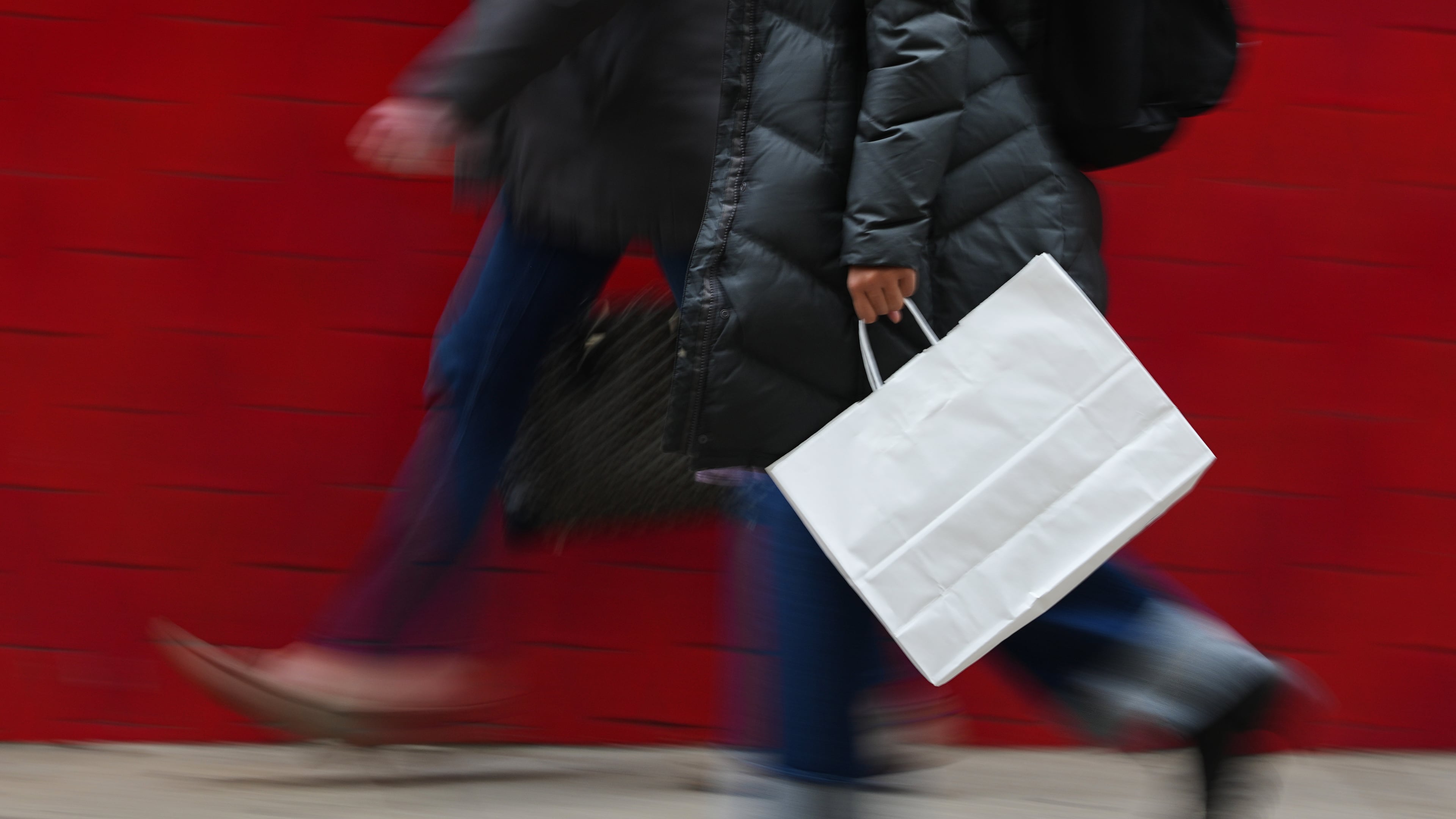 FILE - A person carries a shopping bag in Philadelphia, Dec. 10, 2025. (AP Photo/Matt Rourke, File)
