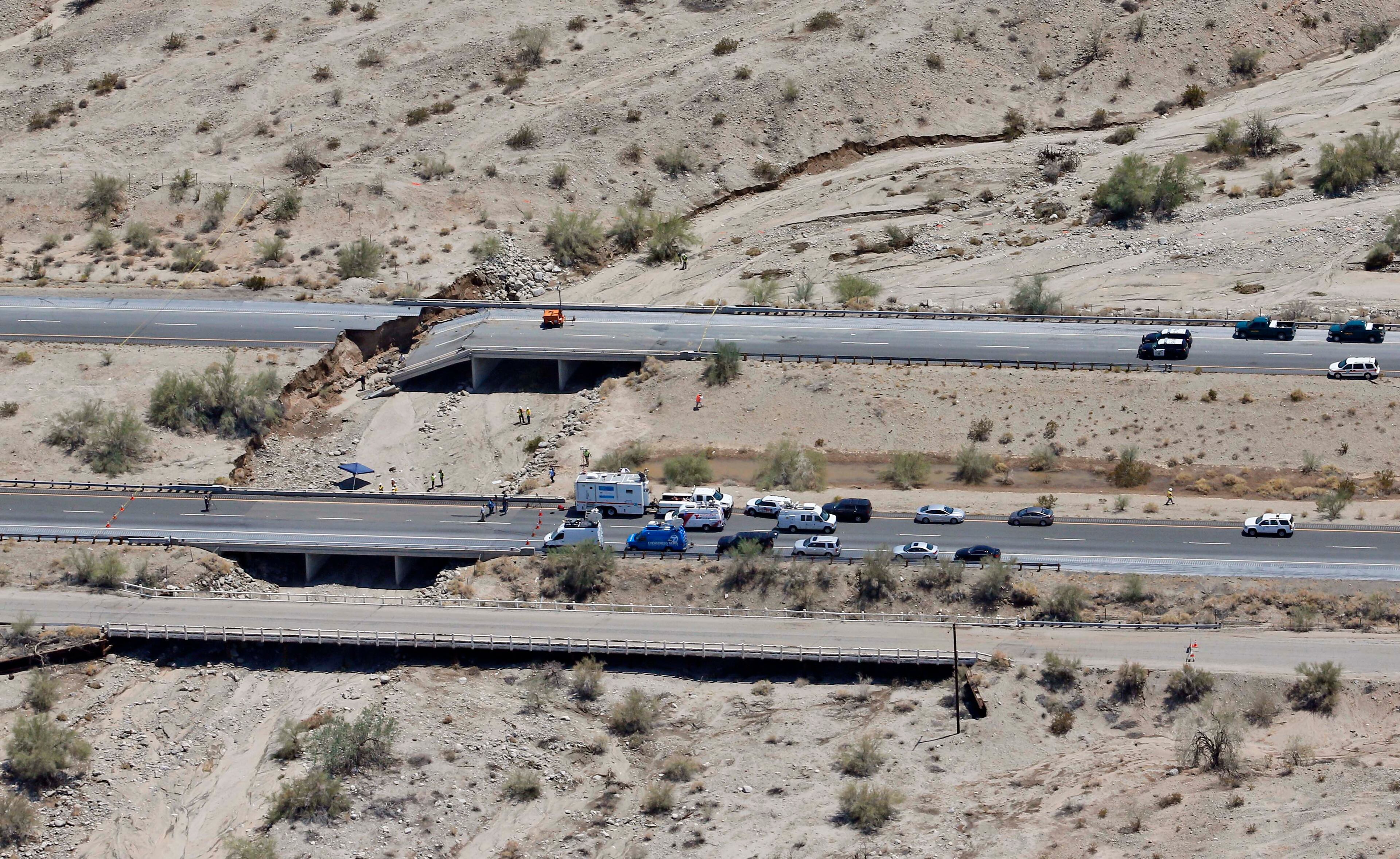 This aerial photo shows the collapsed elevated section of Interstate 10, Monday, July 20, 2015, in Desert Center, Calif. All traffic along one of the major highways connecting California and Arizona was blocked indefinitely when the bridge over a desert wash collapsed during a major storm, and the roadway in the opposite direction sustained severe damage. (AP Photo/Matt York)