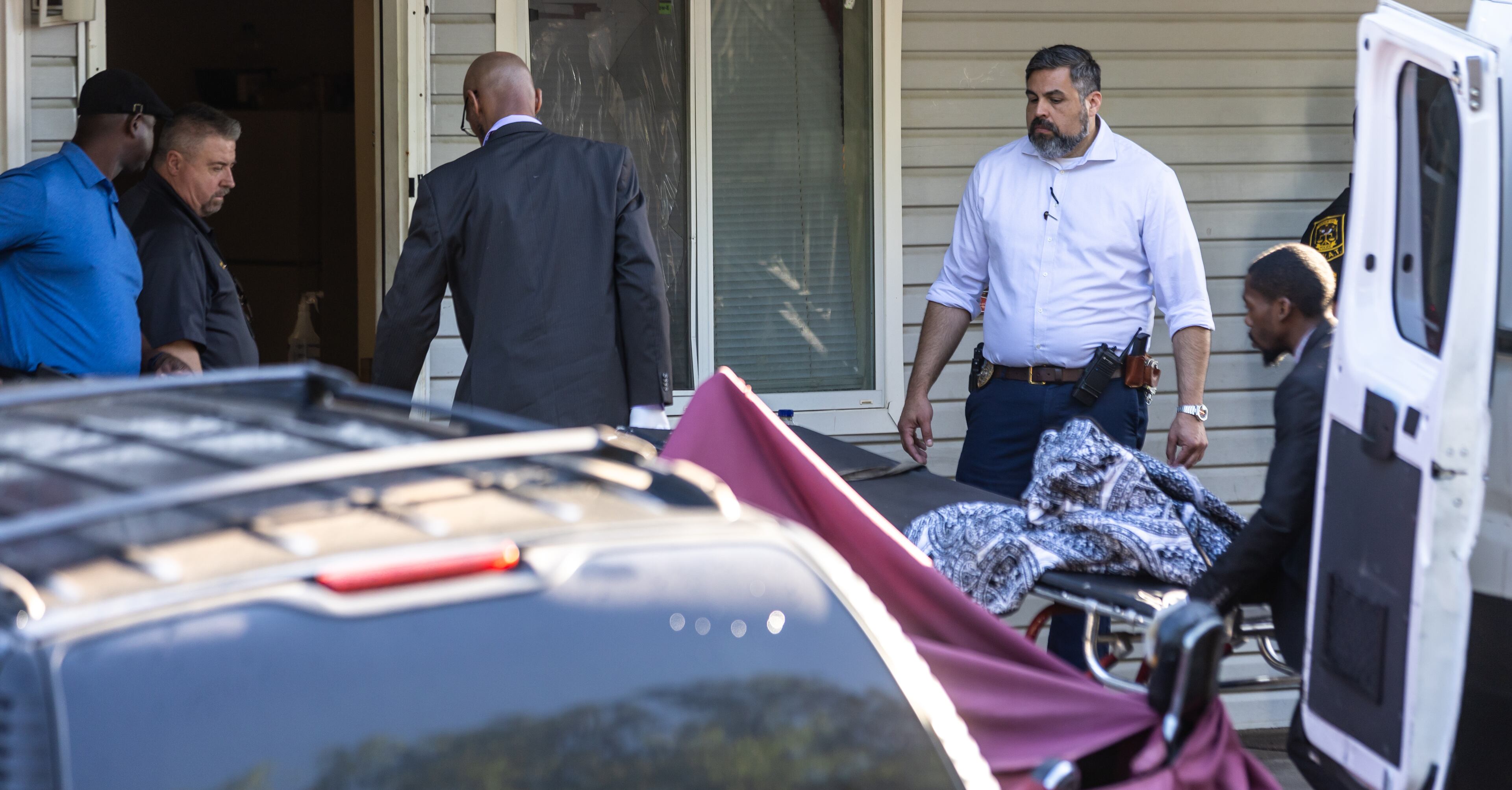 A funeral home transport arrives at an extended stay motel in DeKalb County, where two people were fatally shot early Tuesday. (John Spink/AJC)