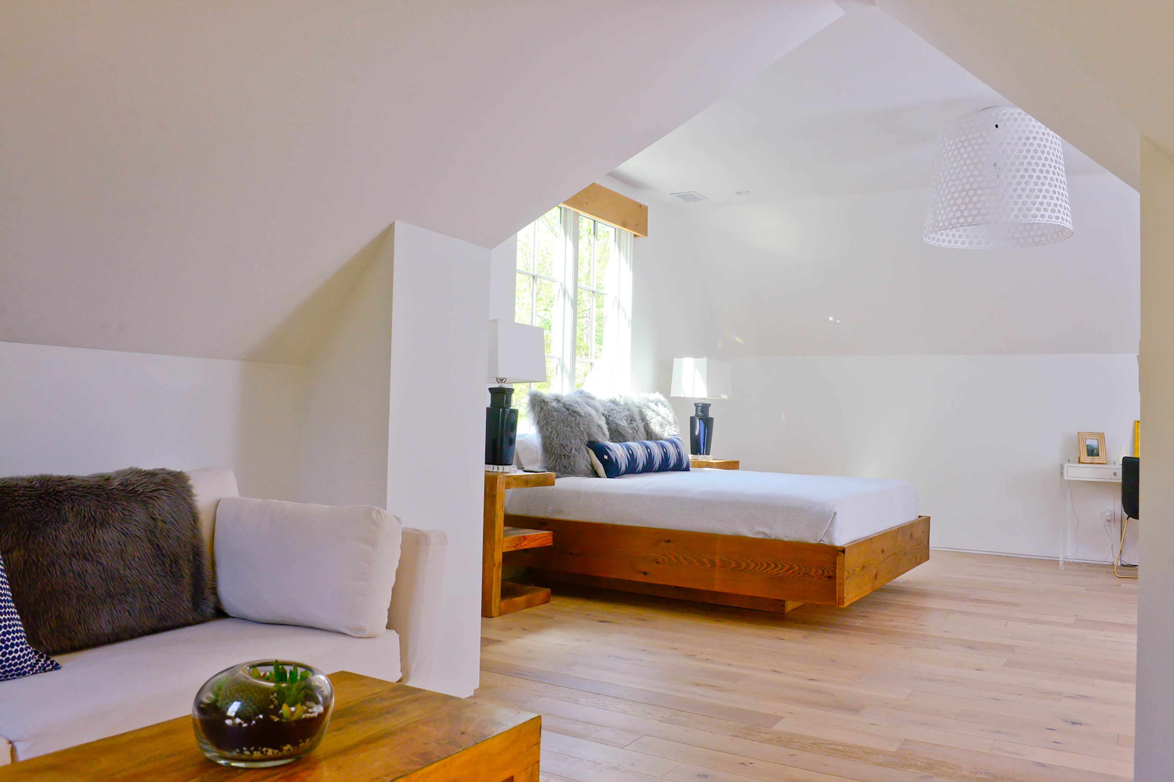 Benjamin Moore Super White walls and light wood floors are the foundation for the modern, Scandinavian look in Eliza's bedroom. The clean lines of the bed and nightstands keep things simple, while furry pillows and accessories add texture and hints of color.