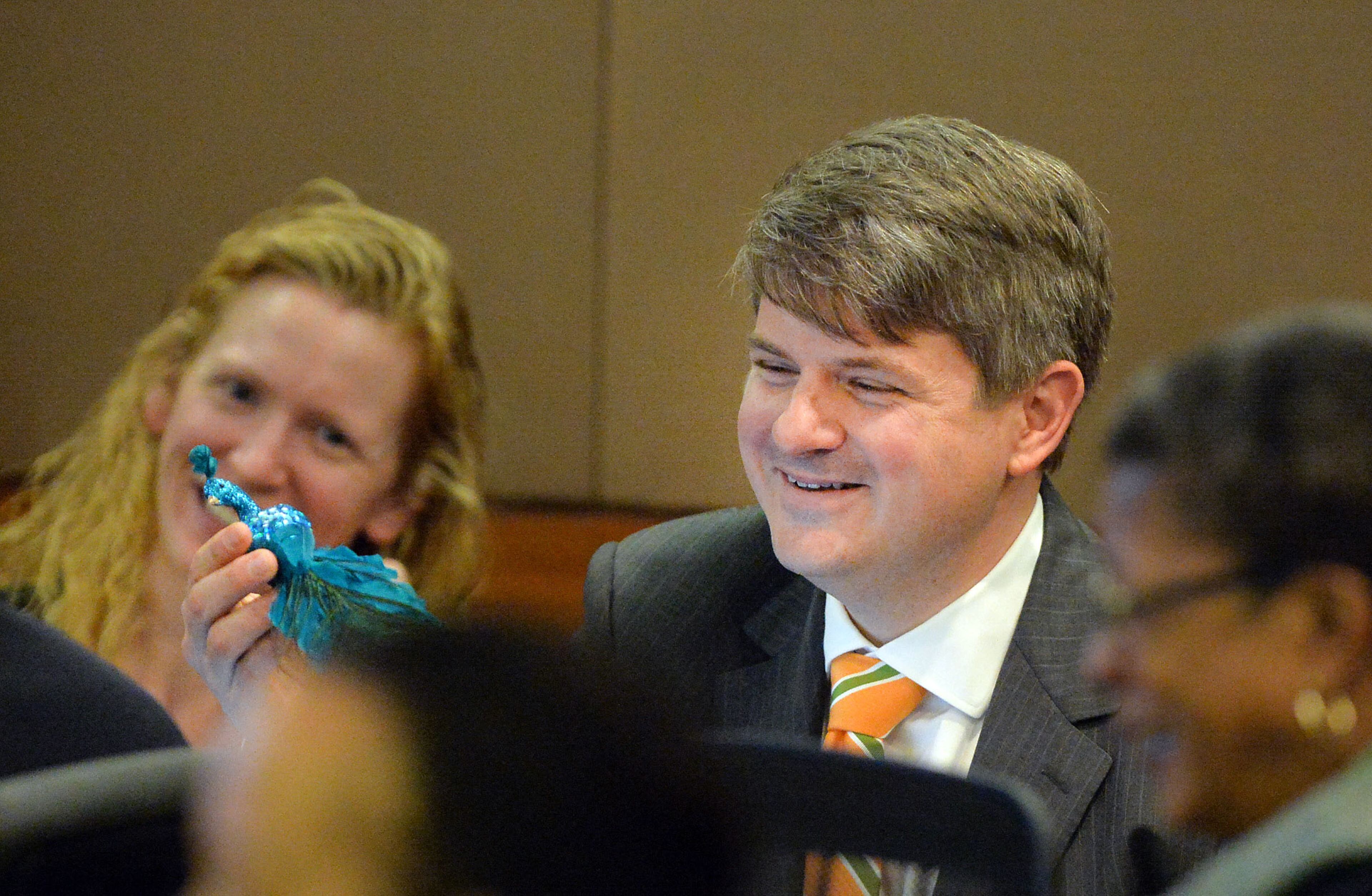 Defense attorney W. Scott Smith admires the Green Peacock Award presented to him by Fulton County Superior Court Judge Jerry Baxter in honor of St. Patrick's Day. (Atlanta Journal-Constitution, Kent D. Johnson, Pool)