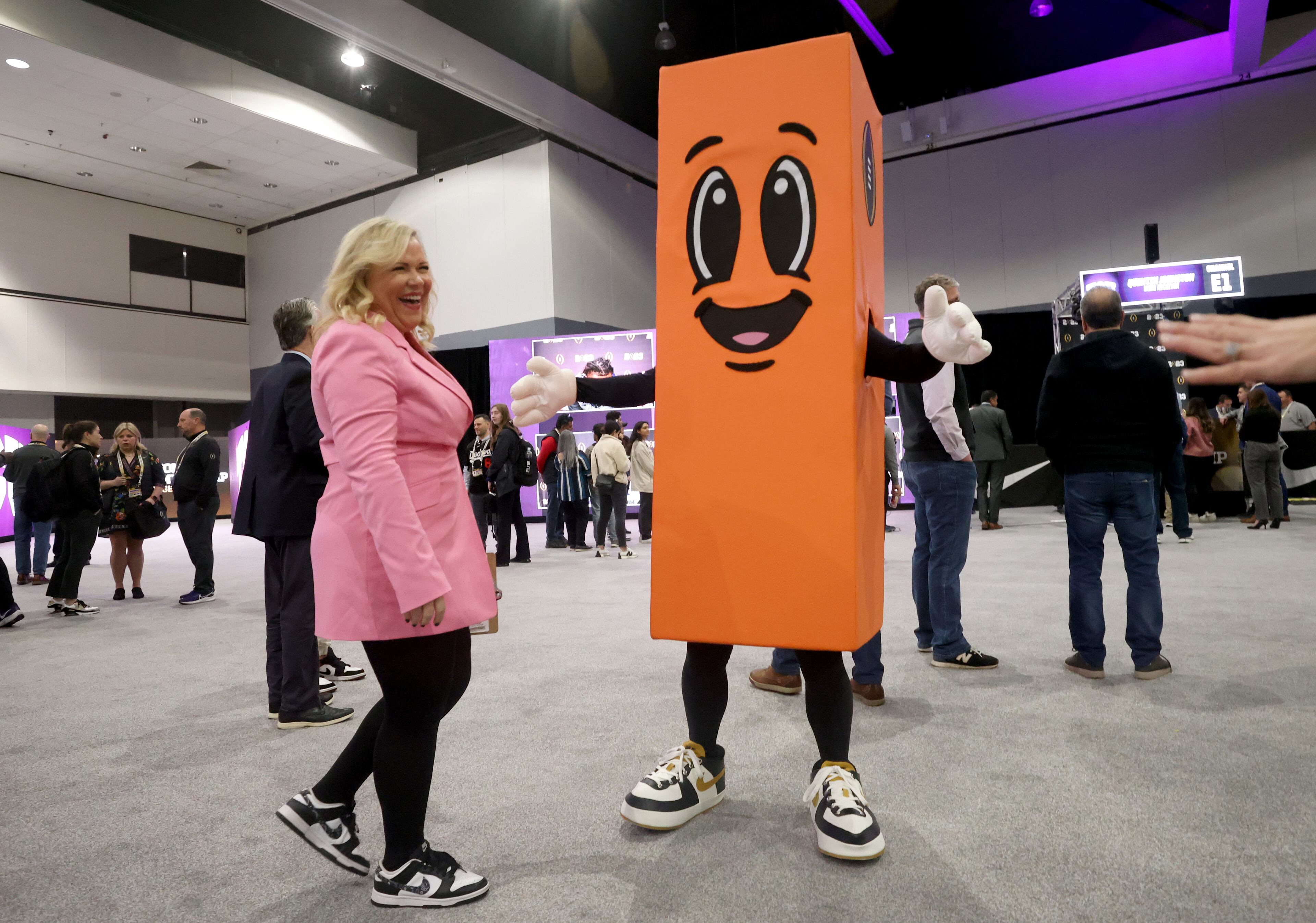 ESPN sports reporter Holly Rowe meets Perry the Pylon, a new mascot, during TCU’s media day at the Los Angeles Convention Center, Sat., Jan. 7, 2023, in Los Angeles, Ca. Georgia plays TCU for the 2023 College Football Playoff National Championship Mon. Jan. 9, 2023, at SoFi Stadium. (Jason Getz / Jason.Getz@ajc.com)