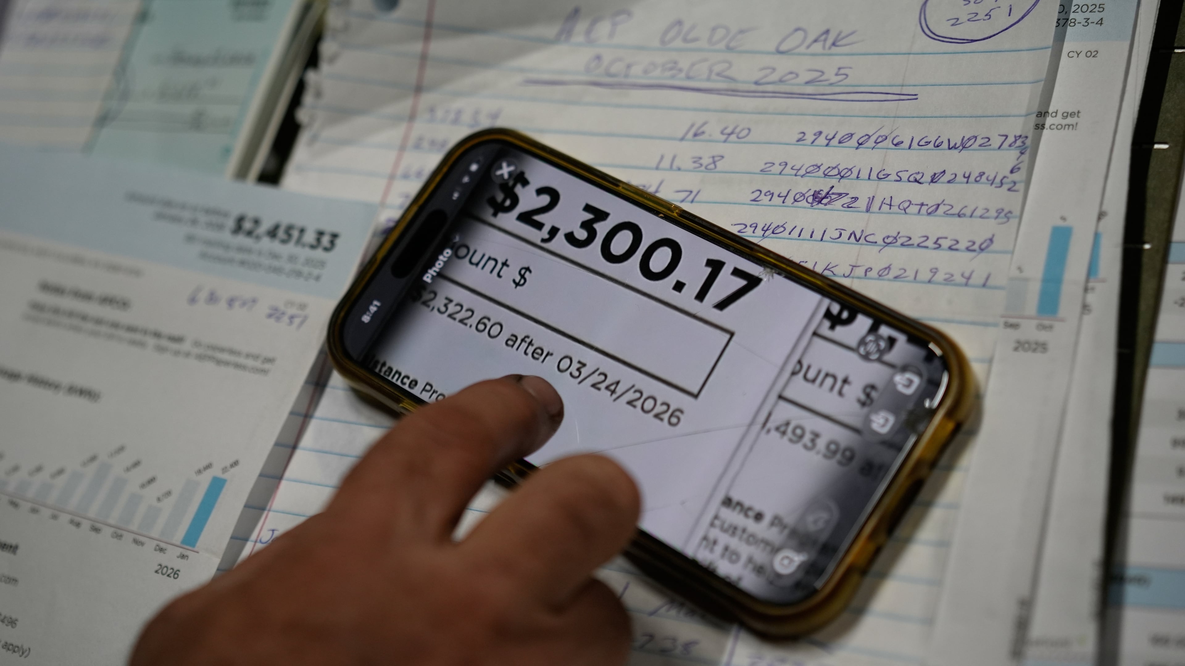FILE - Eric Pinson, manager and resident of the Lock 24 RV Park and Campground, one of two such locations he manages in the area, looks over the business' electric bills, at his home at the campground in Racine, Ohio, March 13, 2026. (AP Photo/Carolyn Kaster, File)