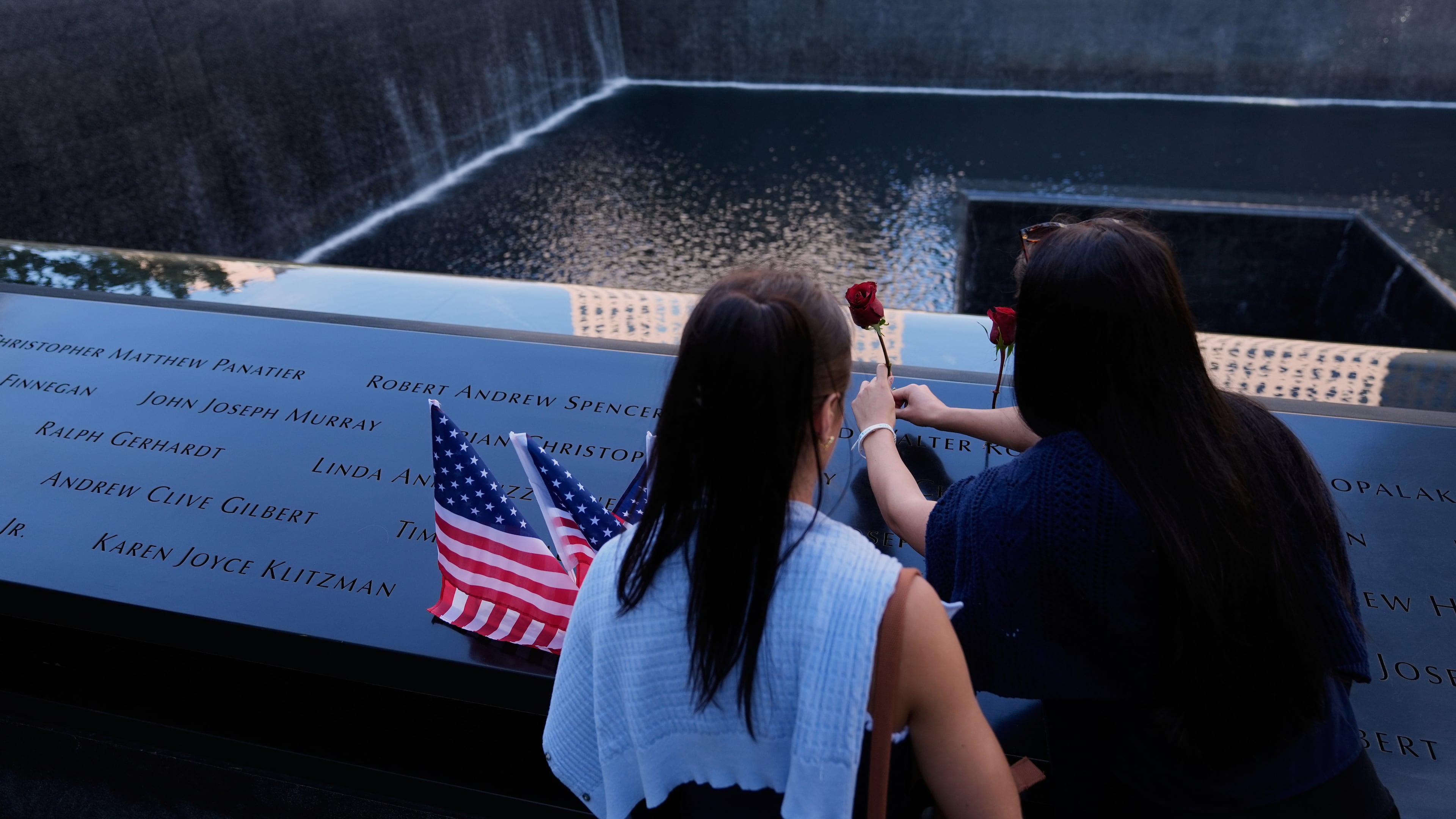 FILE - Ainsley, right, and Sarah Jurccak place a flower in the name of a relative during a ceremony to mark the 24th anniversary of the 9/11 attacks, Sept. 11, 2025, in New York. (AP Photo/Seth Wenig, File)