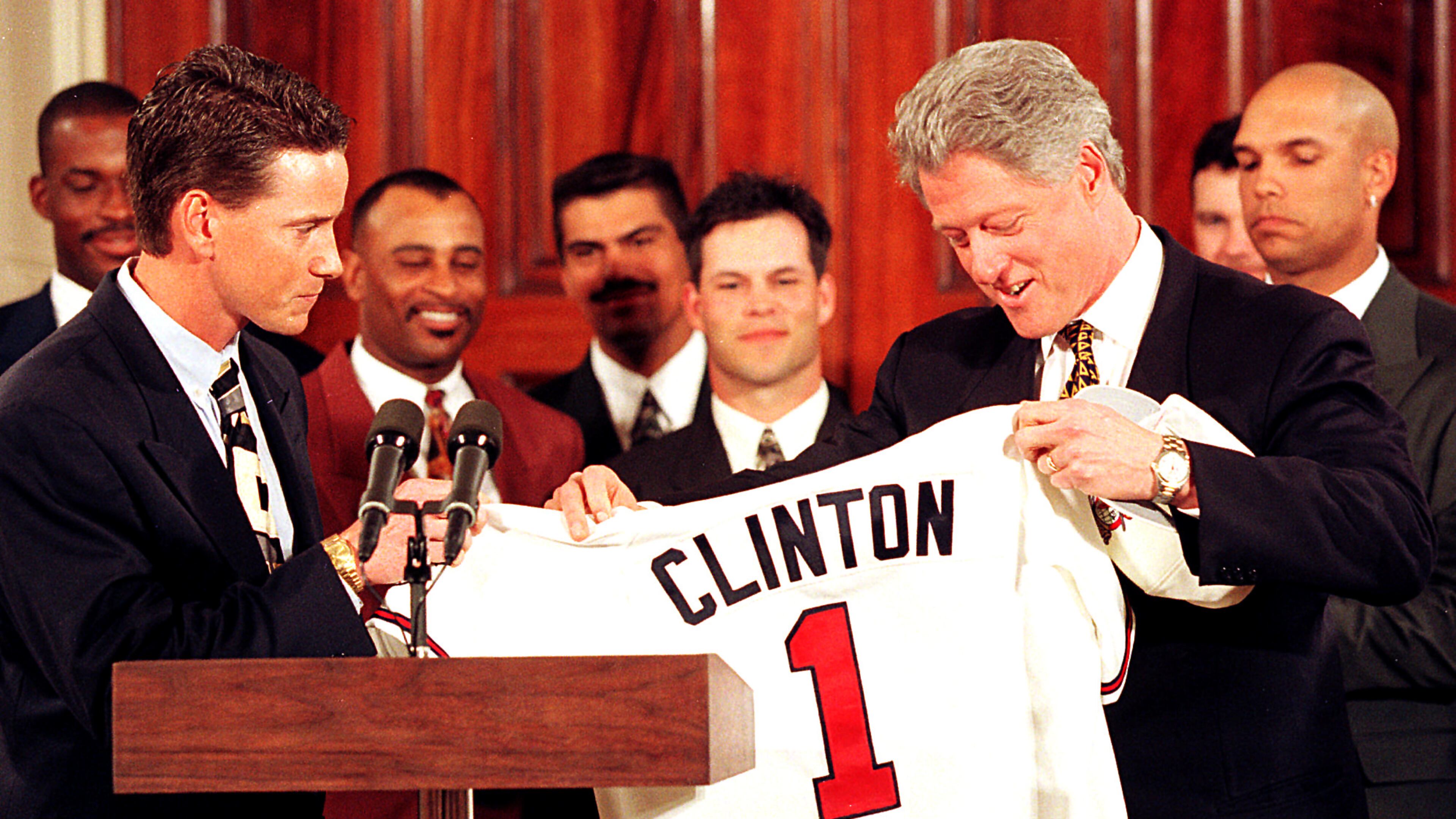 The World Champion Atlanta Braves of 1996 visit the White House. Tom Glavine, the winner of series-clinching Game 6 against Cleveland, presents President Bill Clinton with a Braves uniform top. Picture in the background from left to right: Fred McGriff, Dwight Smith, Eddie Perez, Mike Mordecai, Greg Michael and David Justice. (Photo by Rick McKay/Cox Washington Bureau)