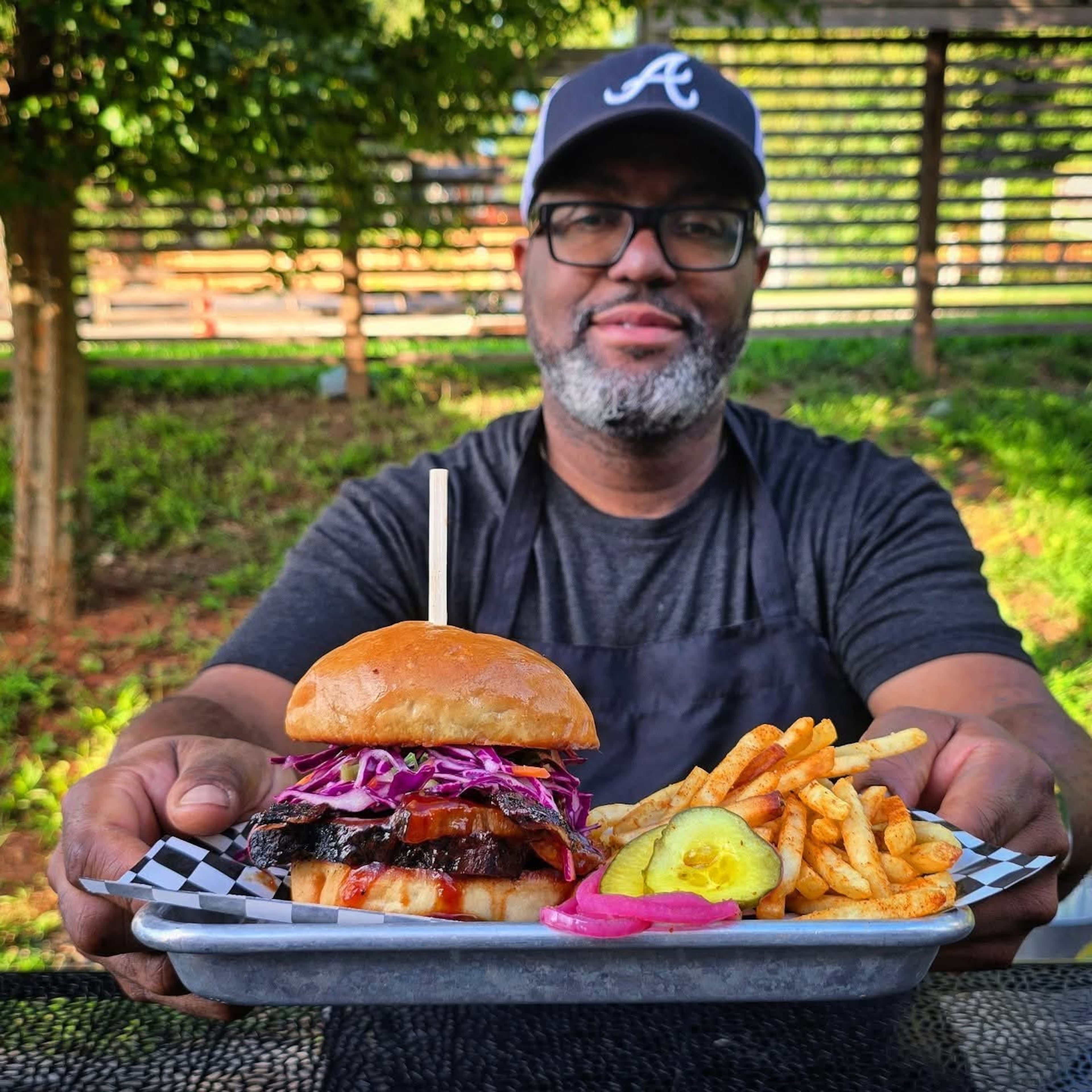 Jimmie’s Jerk Barbecue’s Jimmie Jackson and his brisket sandwich. (Courtesy of Jimmie’s Jerk Barbecue)