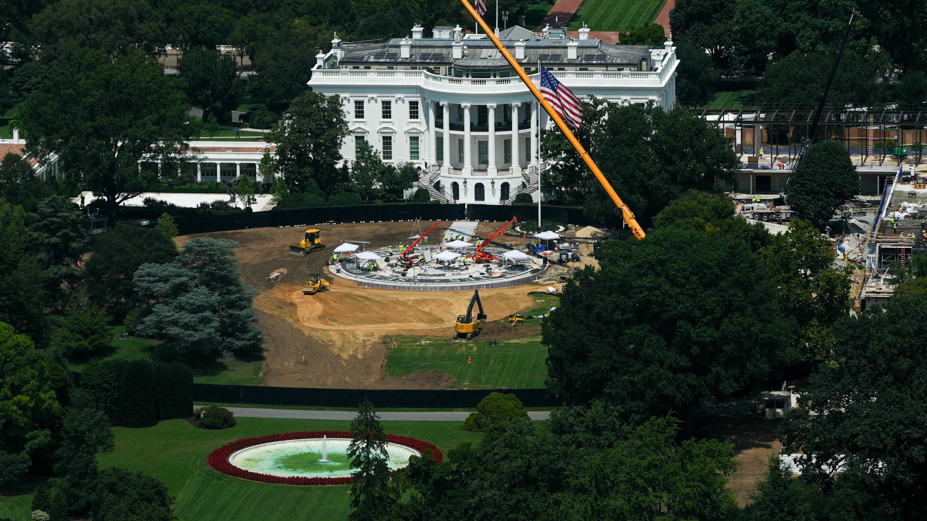 Workers build a helipad on the South Lawn of the White House, left, and continue construction on the new White House ballroom, right, as seen from the Washington Monument, Monday, Aug. 17, 2026, in Washington. (AP Photo/Julia Demaree Nikhinson)