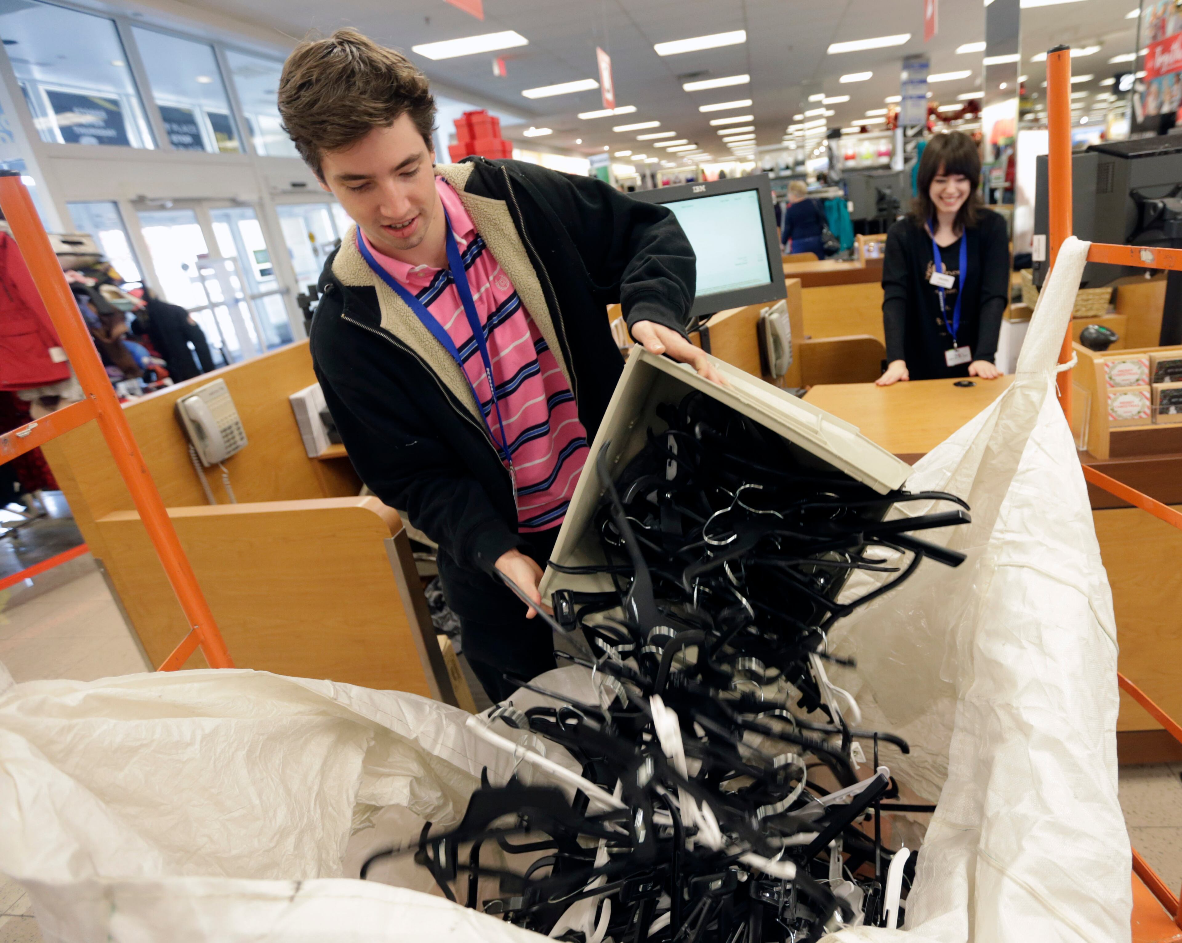 Tor Wendel recycles hangers from the Kohl's checkout stands Friday morning.