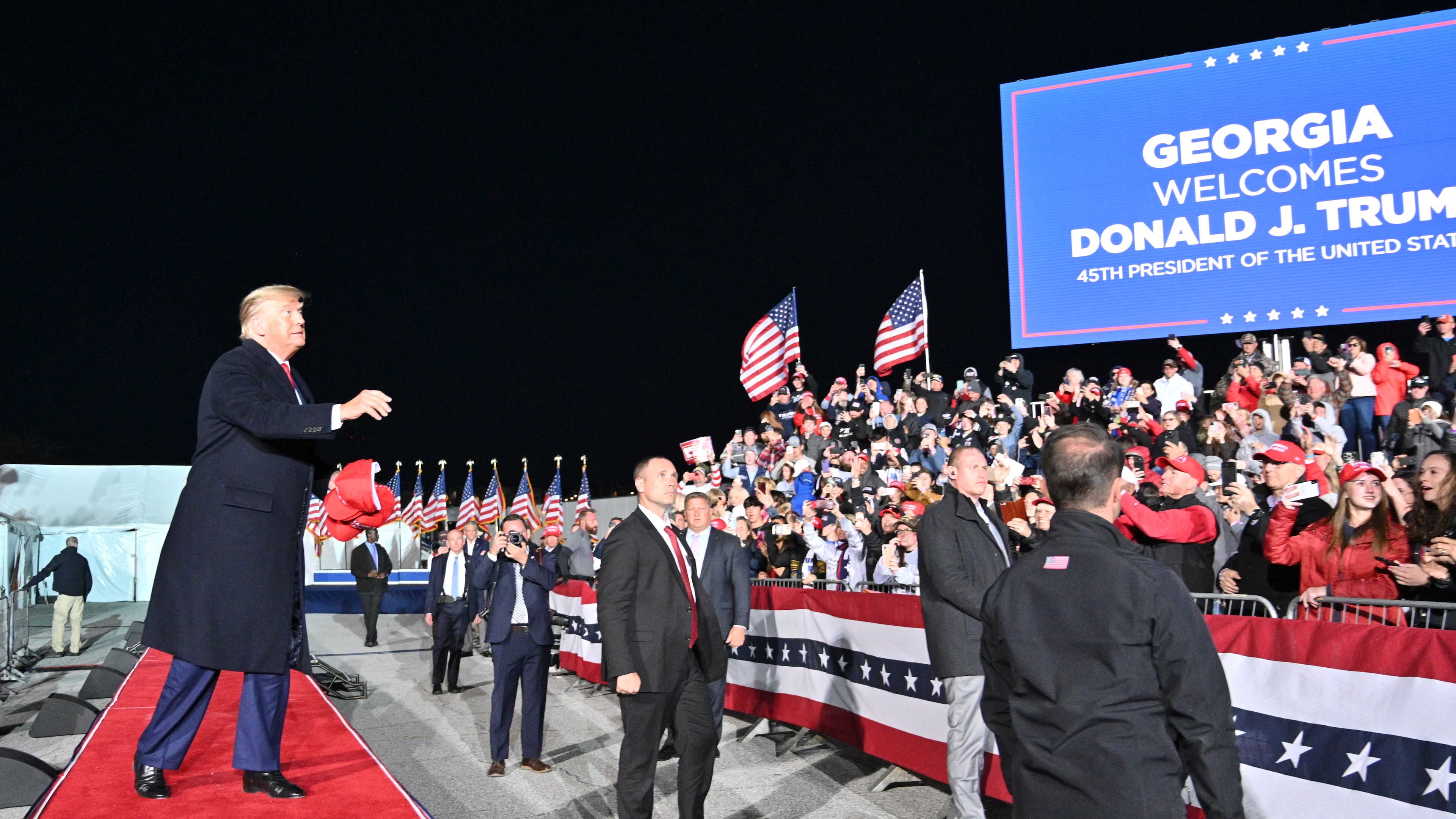 Former President Donald Trump throws hats as he enters the stage during a March 2022 rally for Georgia GOP candidates at Banks County Dragway in Commerce. A new University of Georgia poll of Republican voters shows Trump with 51% support from respondents to lead a field of possible GOP presidential candidates in 2024. Florida Gov. Ron DeSantis placed second at 30%, making him the only other potential hopeful to finish in double digits. (Hyosub Shin / Hyosub.Shin@ajc.com)