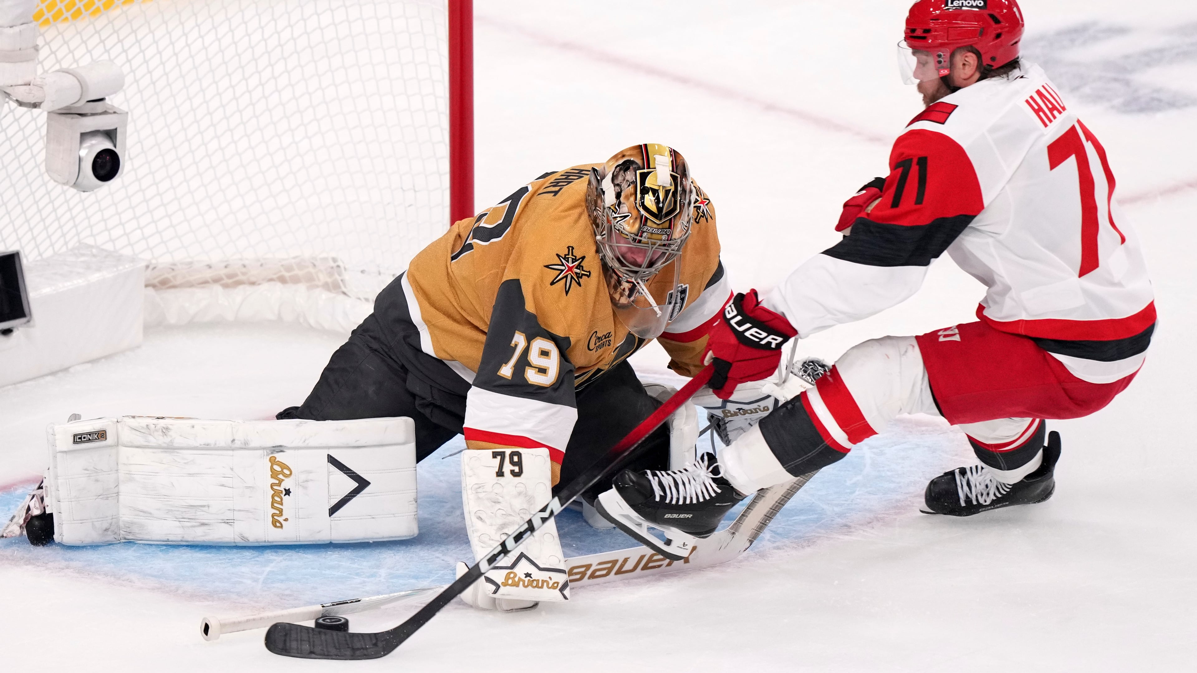 Vegas Golden Knights goaltender Carter Hart, left, stops a shot by Carolina Hurricanes left wing Taylor Hall during the first period in Game 4 of the NHL hockey Stanley Cup Final series Tuesday, June 9, 2026, in Las Vegas. (AP Photo/Candice Ward)