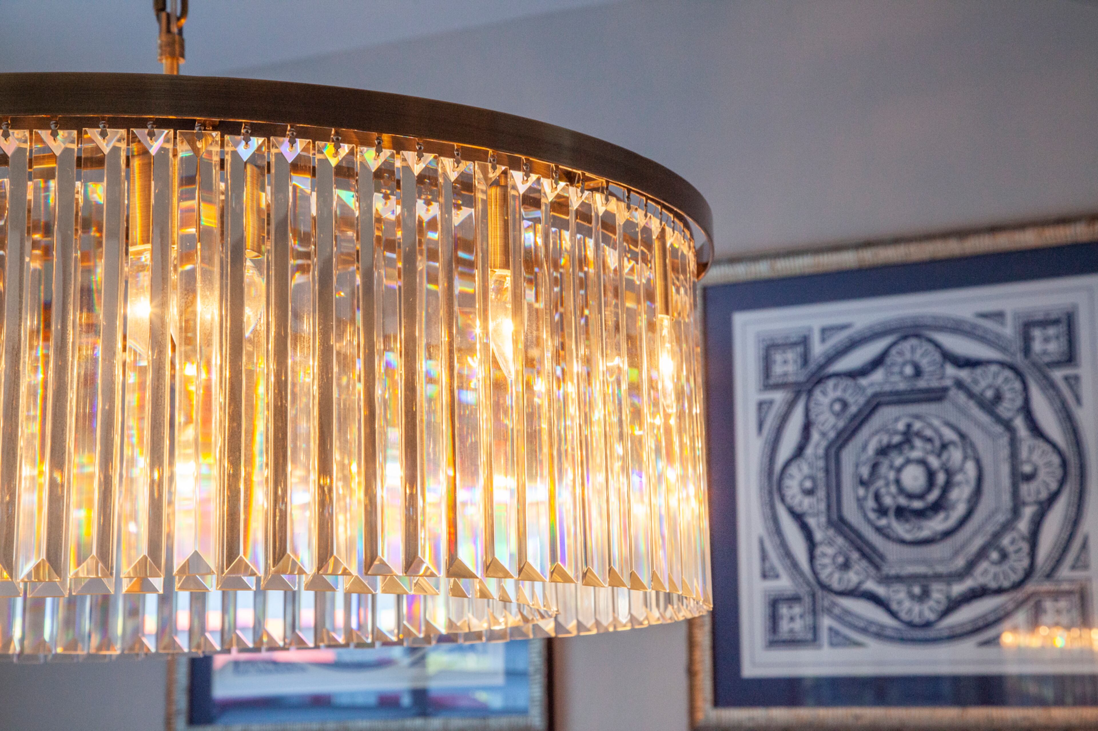 A chandelier from Wayfair offers a soft glow in the dining room and the crystals reflect bits of color in the artwork.