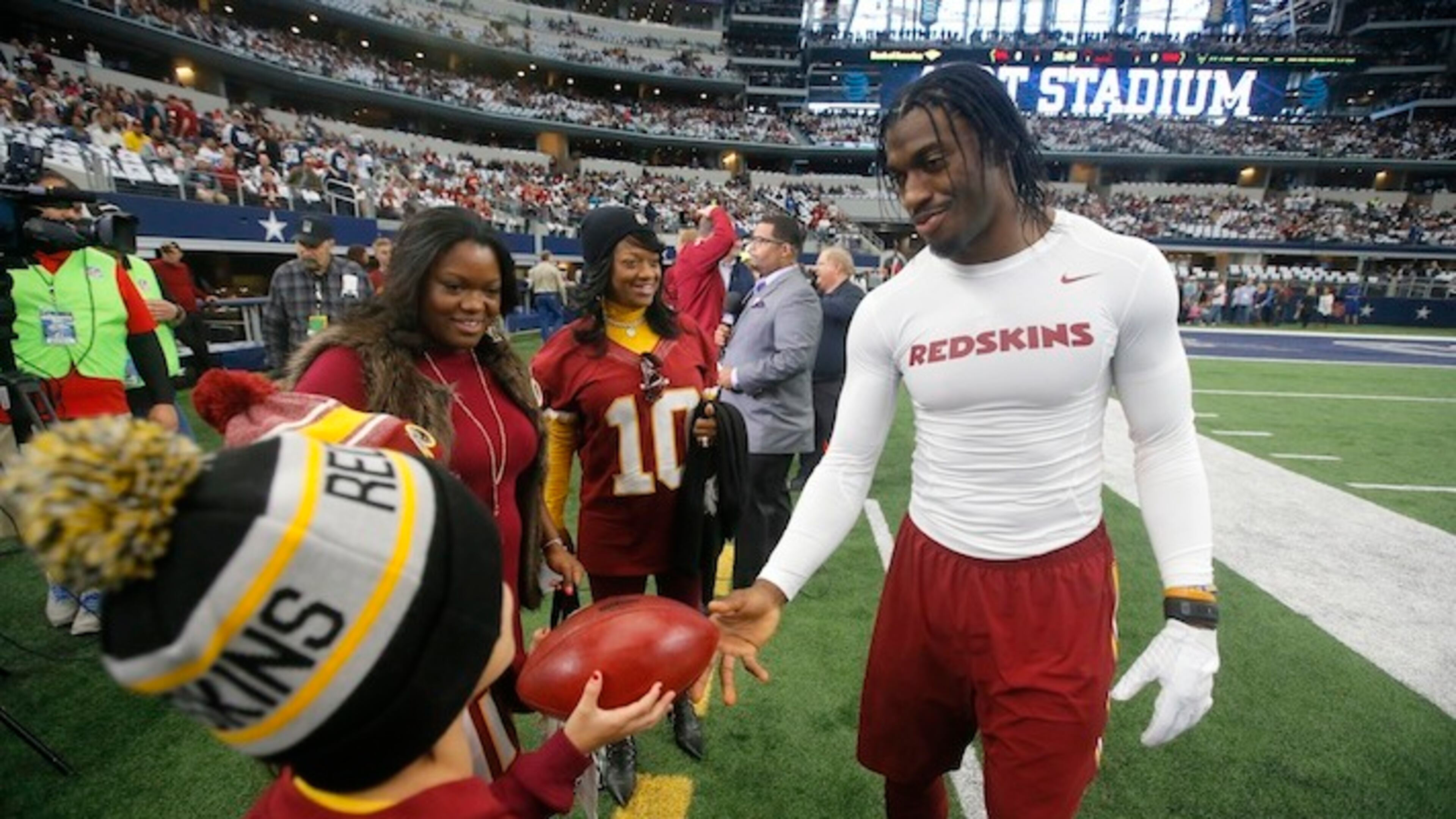 Washington Redskins' Robert Griffin III signs autographs before an NFL football game against the Dallas Cowboys on Sunday, Jan. 3, 2016, in Arlington , Texas. (AP Photo/Michael Ainsworth)
