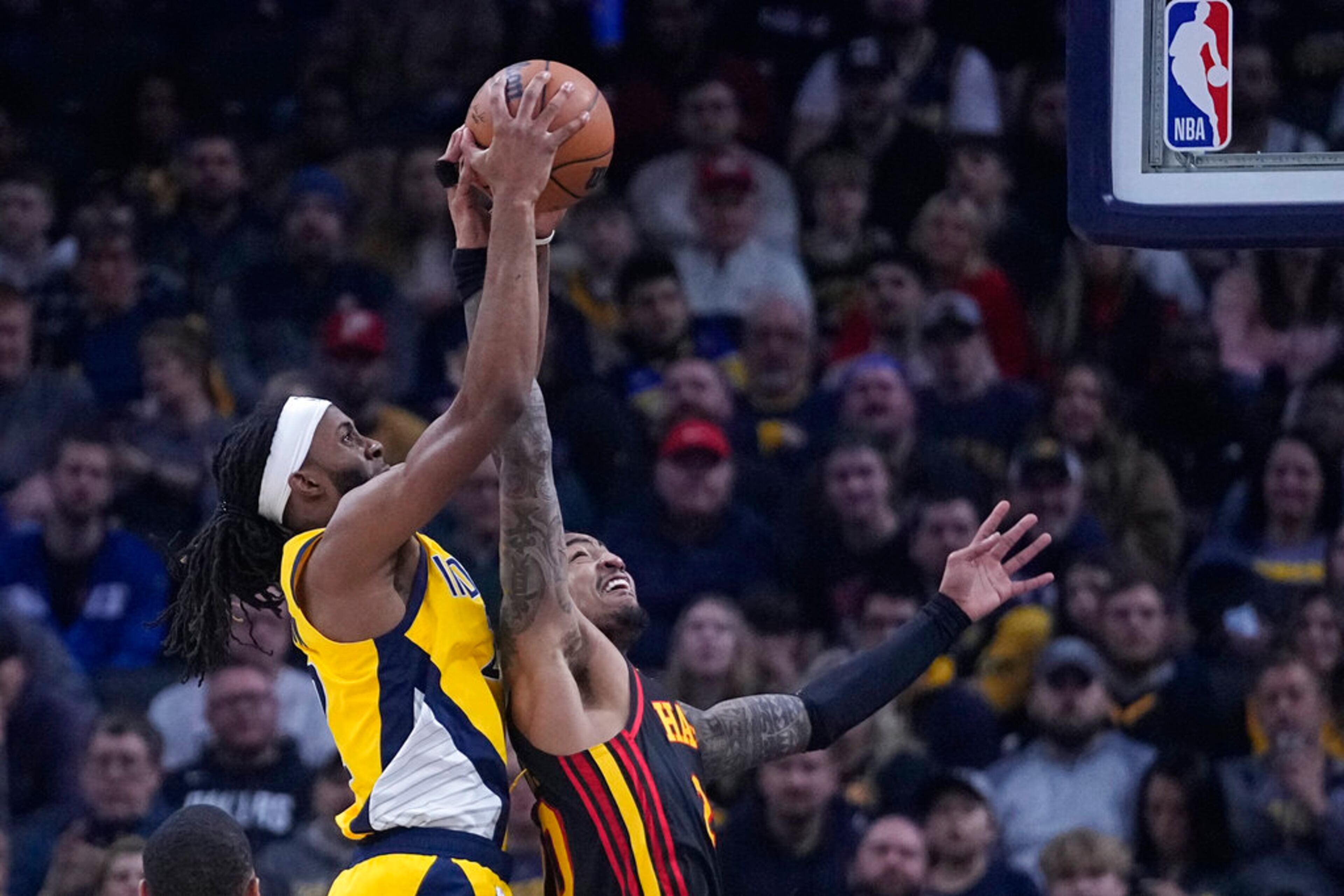 Indiana Pacers' Isaiah Jackson (22) and Atlanta Hawks' John Collins (20) vie for a rebound during the first half of an NBA basketball game Friday, Jan. 13, 2023, in Indianapolis. (AP Photo/Darron Cummings)