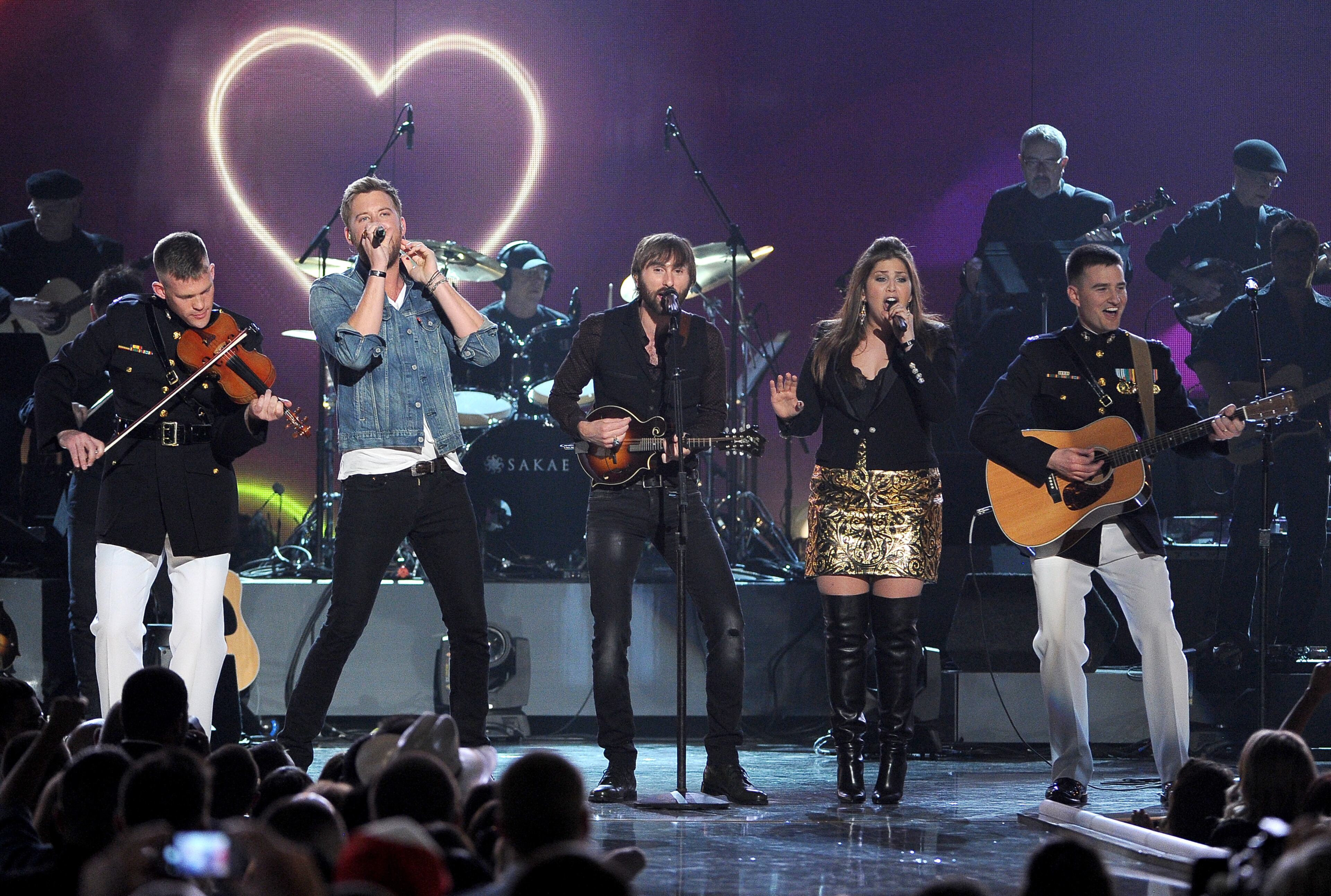 John Ed Auer, of the U.S. Marine Corps, and from left, Charles Kelley, Dave Haywood, Hillary Scott, of the musical group Lady Antebellum, and Matt Smith, of the U.S. Marine Corps, perform at ACM Presents an All-Star Salute to the Troops on Monday, April 7, 2014, in Las Vegas. (Photo by Chris Pizzello/Invision/AP)