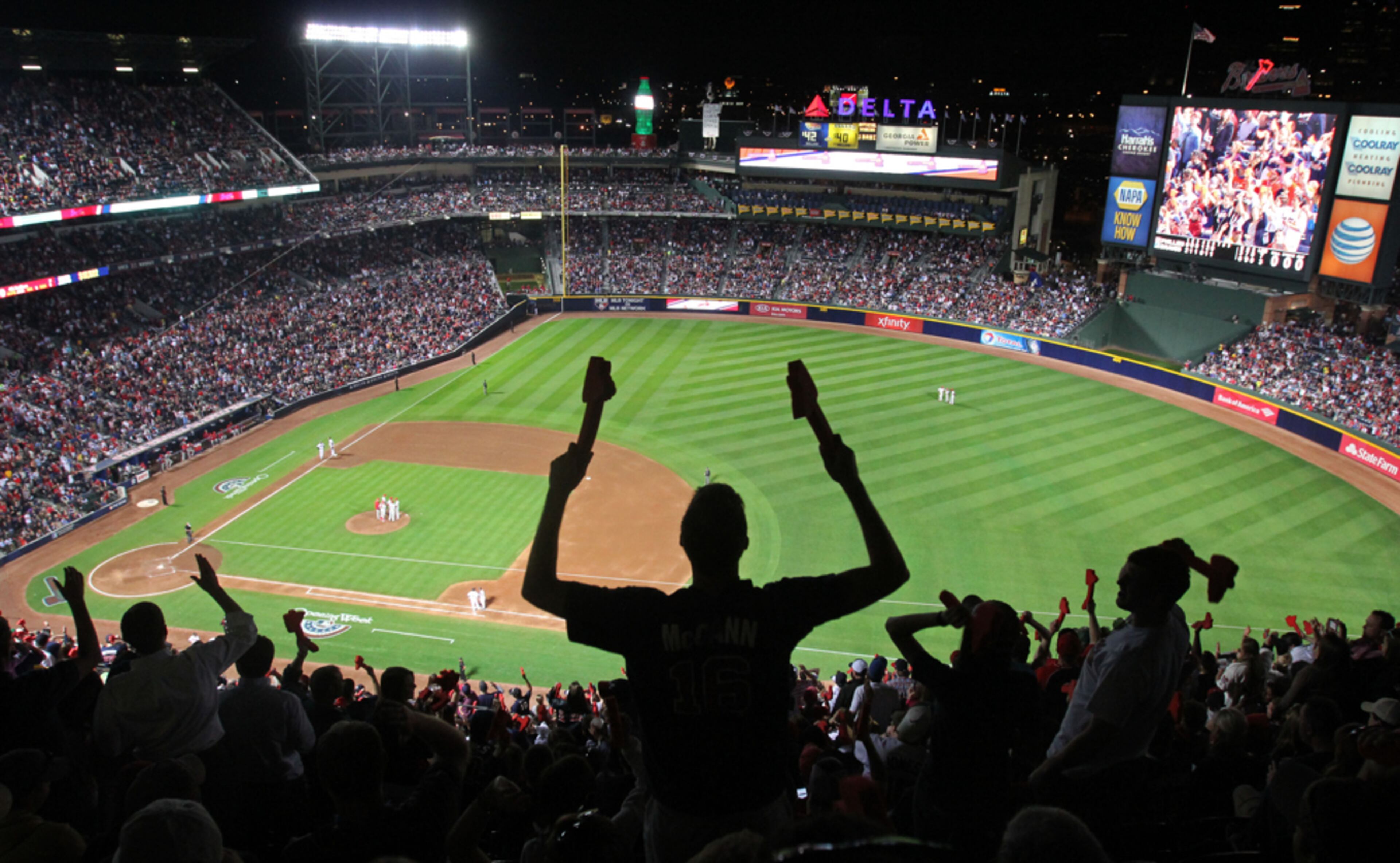 April 1, 2013 - Atlanta, Ga: An Atlanta Braves fan does a double tomahawk chop in the upper deck during a break from the game in the 6th inning in the upper deak of the Atlanta Braves 2013 season opener at Turner Field Friday night in Atlanta, Ga., April 2, 2013. Getz said, "While covering a Braves game, I like to go up to the upper deck and get a different angle of the field. What I found was a great way to get a silhouette of a fan with a scenic image of the field behind him." JASON GETZ / JGETZ@AJC.COM