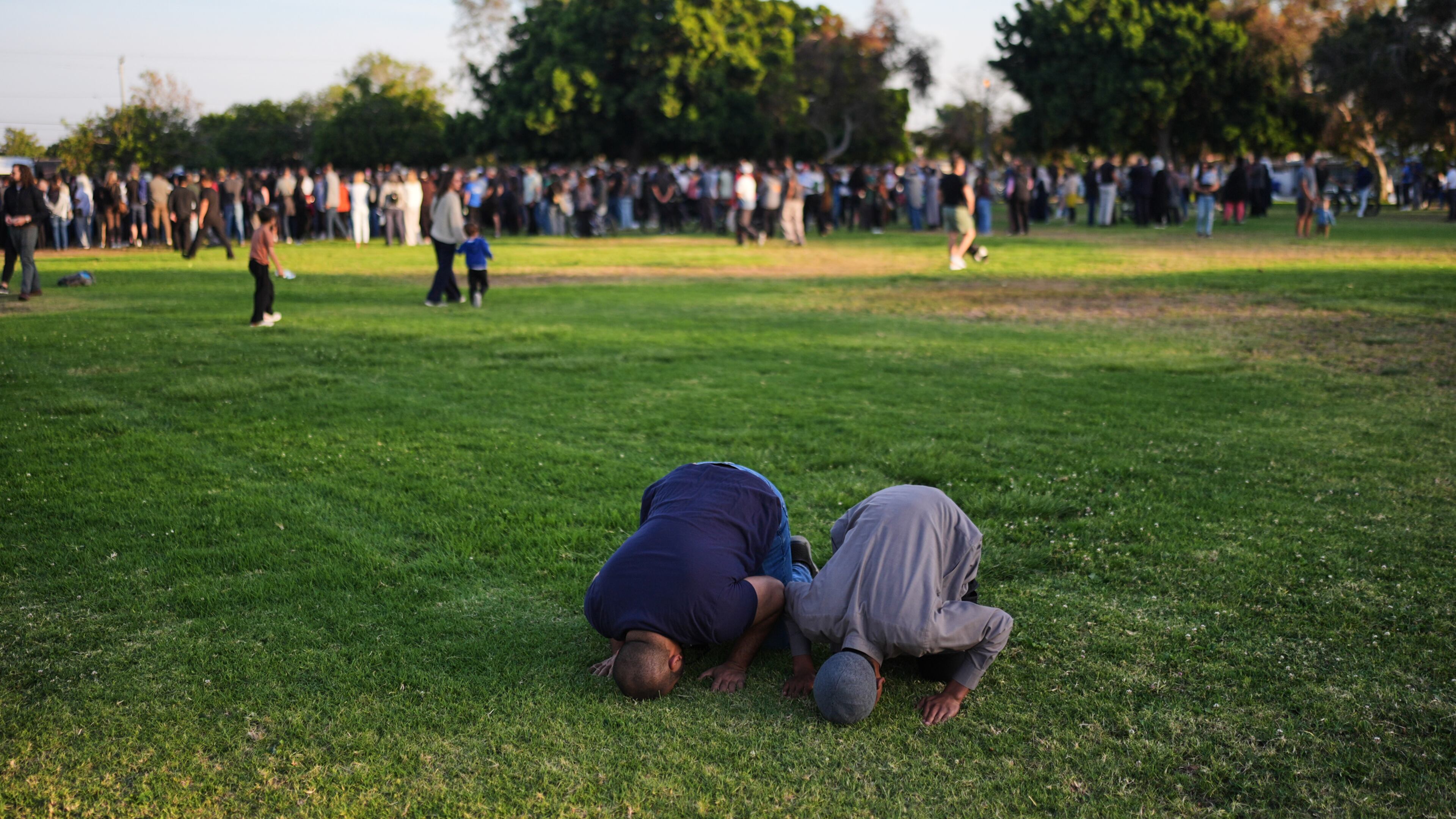 Two people pray during a vigil, the day after a shooting, outside of the Islamic Center of San Diego, Tuesday, May 19, 2026, in San Diego. (AP Photo/Jae C. Hong)
