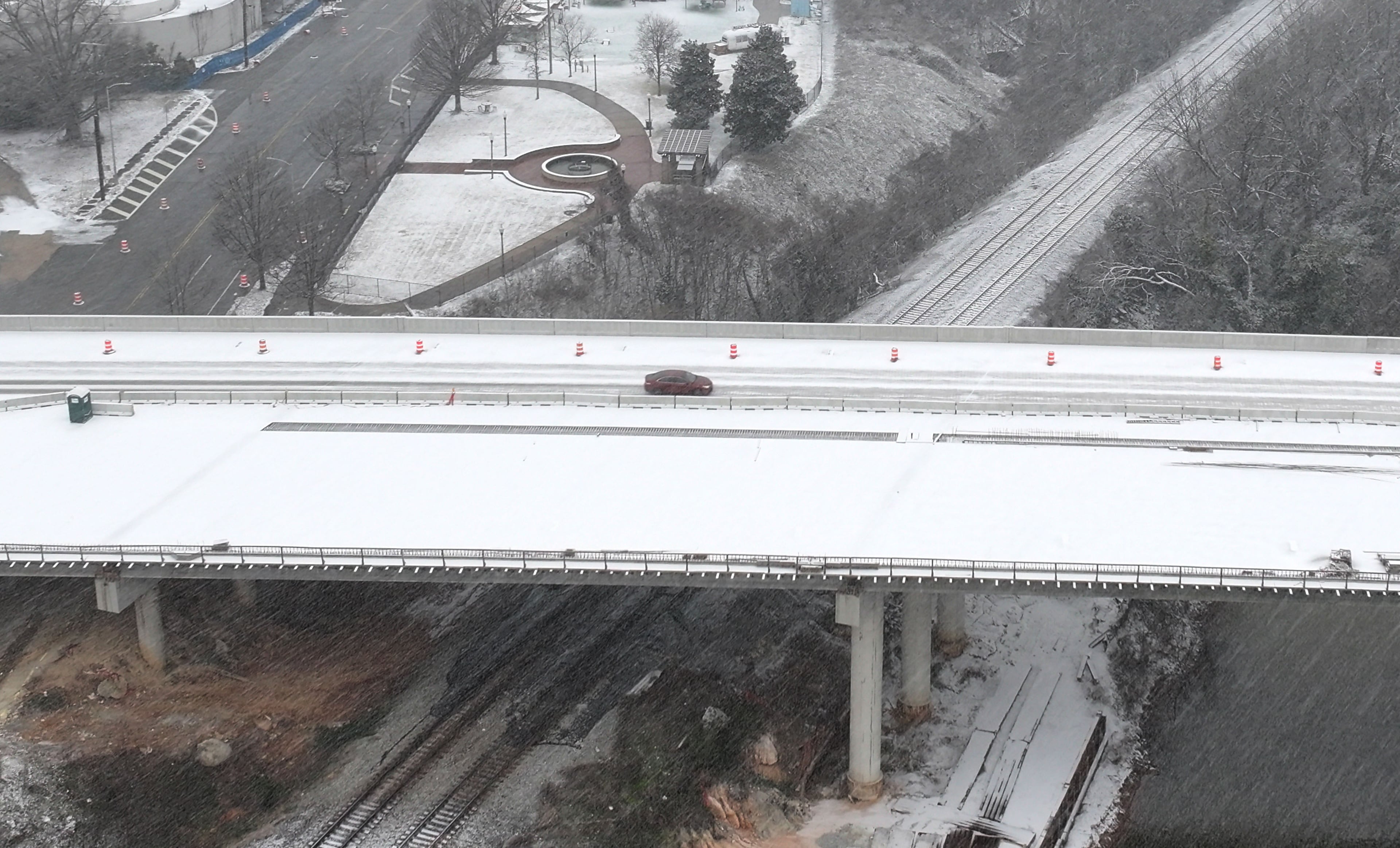 A car travels on snow-covered road near downtown Macon, Tuesday, January 21, 2025. Snow began falling in Atlanta and across Middle and South Georgia on Tuesday afternoon and quickly started accumulating in some areas. The National Weather Service expanded its winter storm warning to encompass Atlanta and some counties north of the city. (Hyosub Shin / AJC)