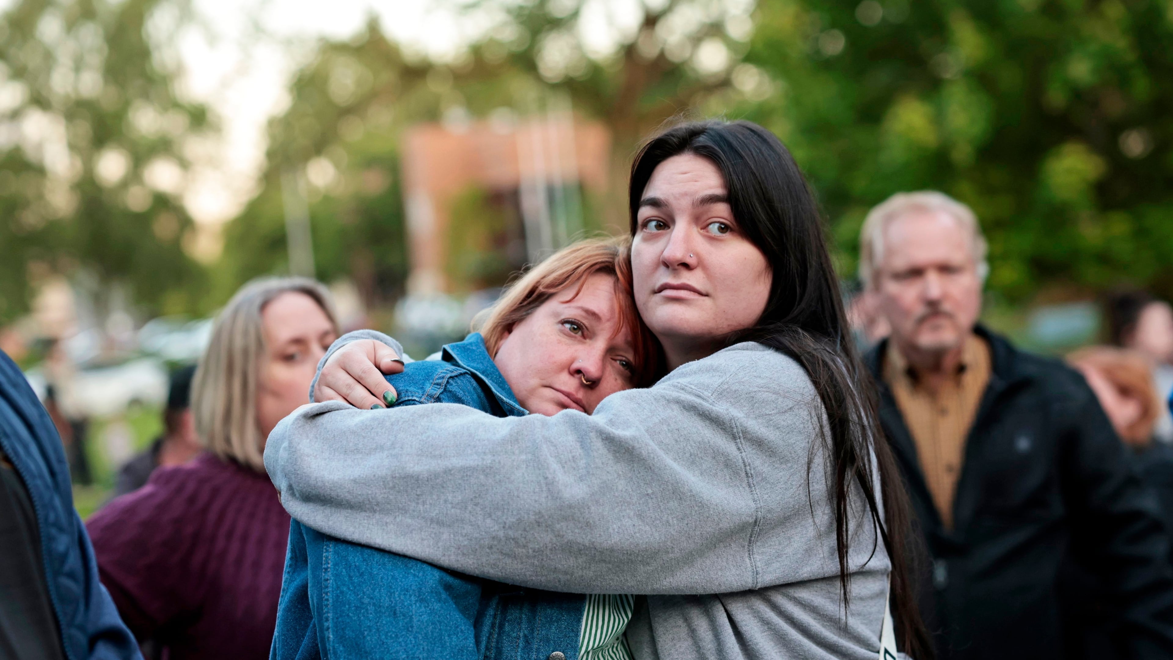 Diana Winther, left, and Kellie Webber, embrace during an evening prayer and vigil in support for the victims and their families impacted by Nippon Dynawave Packaging Co. tank implosion, at R.A. Long Park in Longview, Wash., on Tuesday, May 26, 2026. (Karen Ducey/The Seattle Times via AP)
