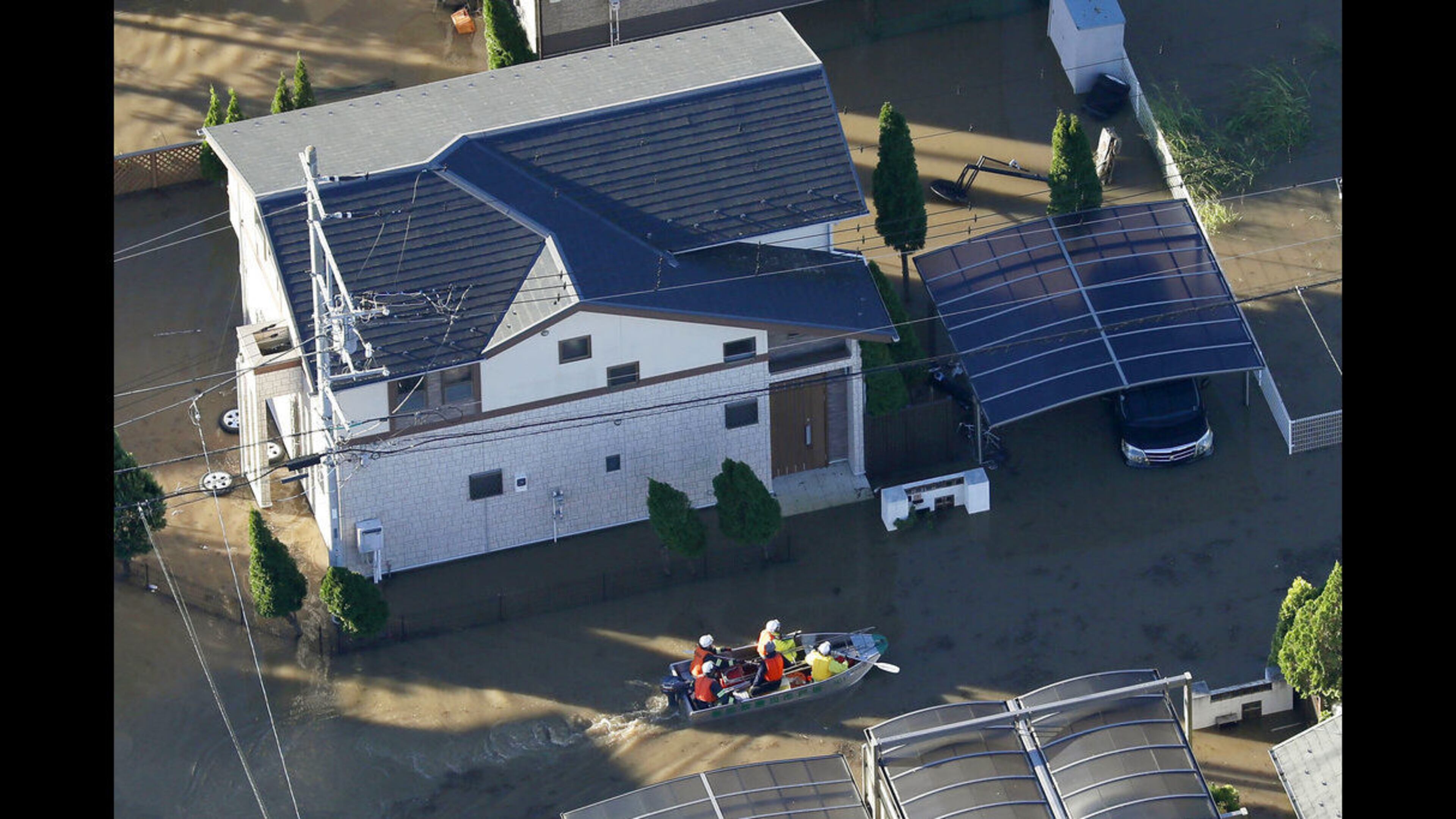Rescuers on a boat make their way through flooded residential area hit by Typhoon Hagibis, in Sakado, on the outskirts of Tokyo, Sunday, Oct. 13, 2019.