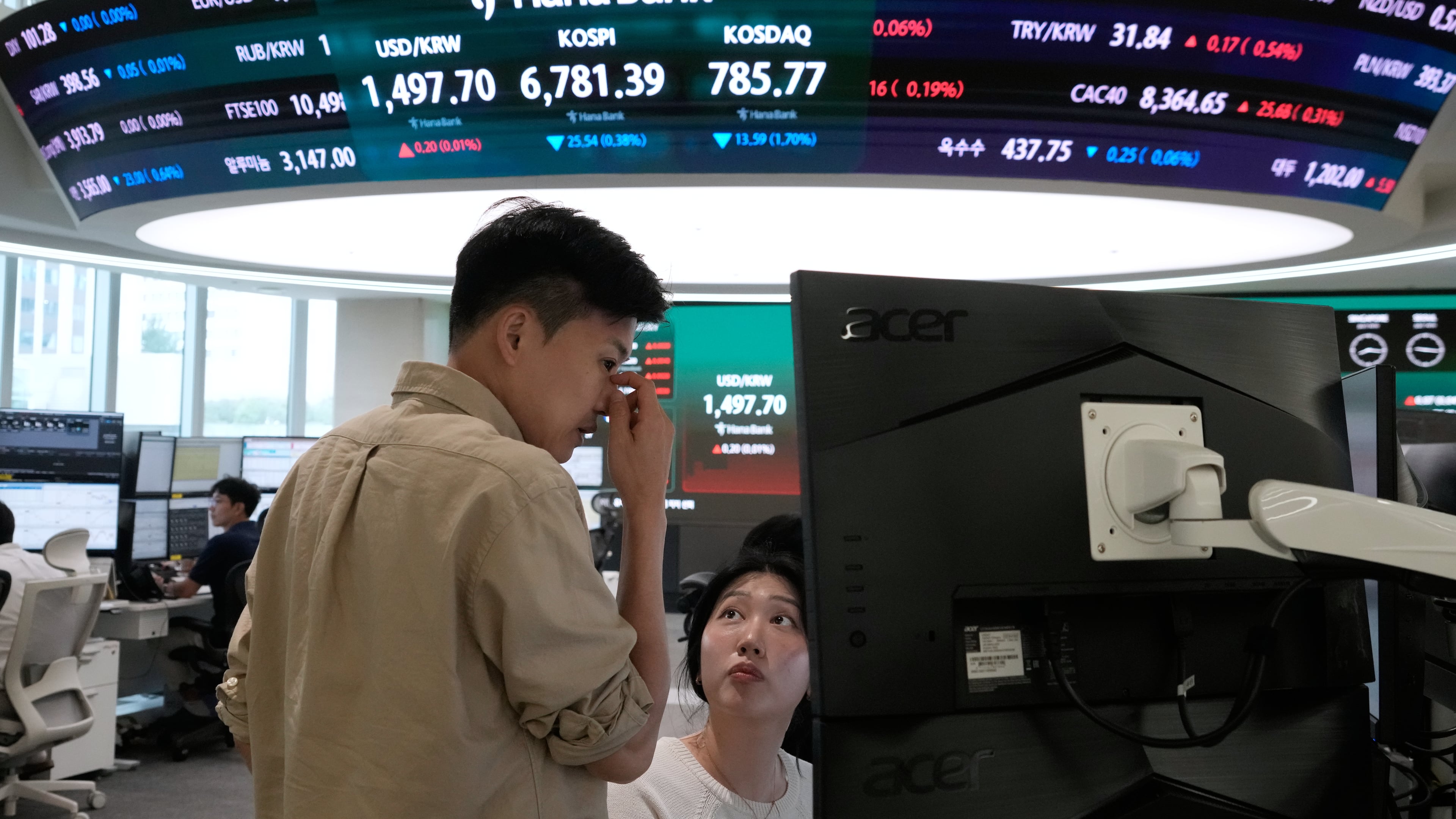 Currency traders work at the foreign exchange dealing room of the Hana Bank headquarters in Seoul, South Korea, Tuesday, July 14, 2026. (AP Photo/Ahn Young-joon)