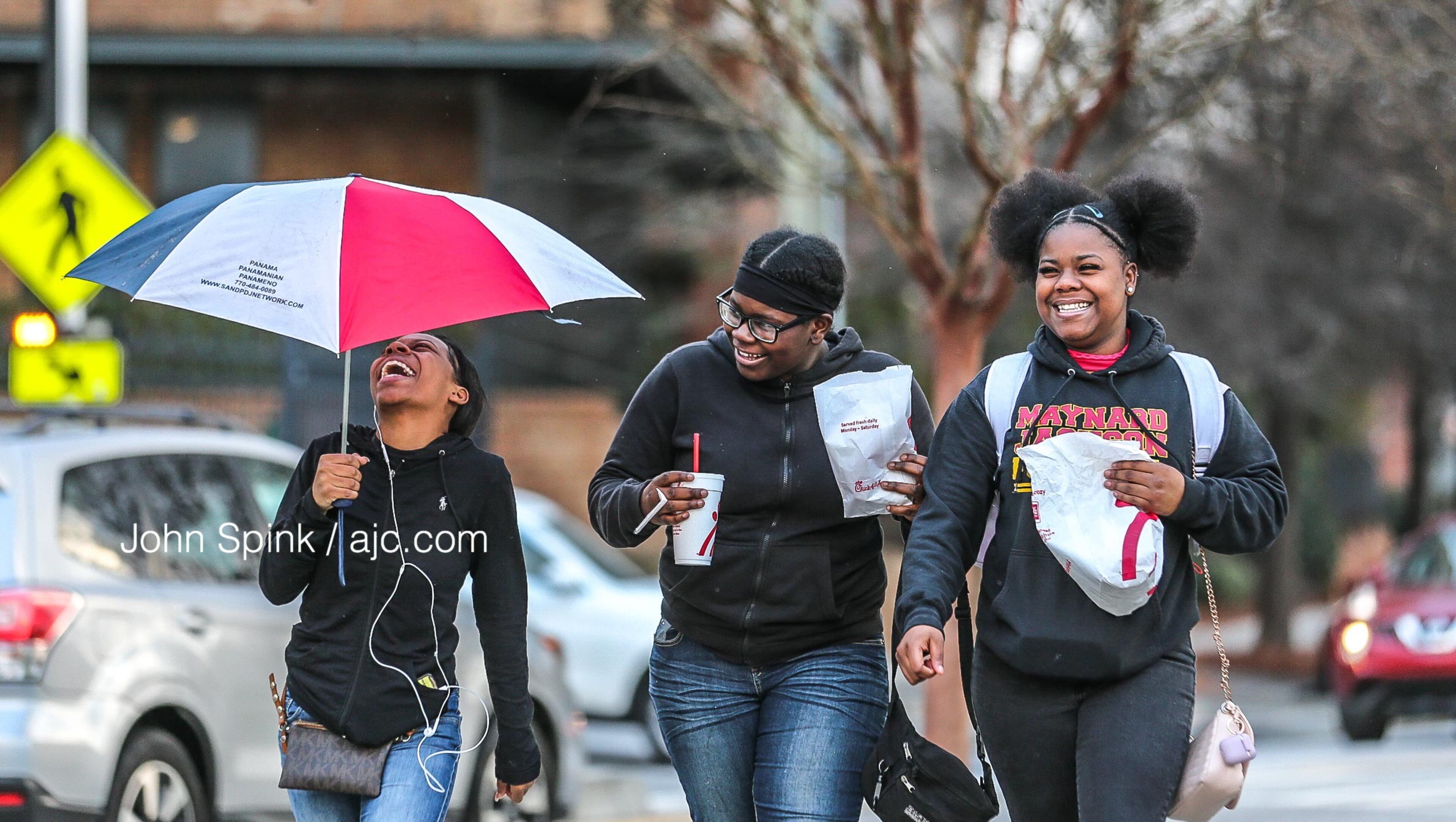 From left to right, Kimberly Williams, 17, Joanna Mathis, 13, and Santonya Mathis, 16, walk in snow flurries in the 800 block of Glenwood Avenue. Any snow that falls Friday won't amount to much, according to Channel 2 Action News.