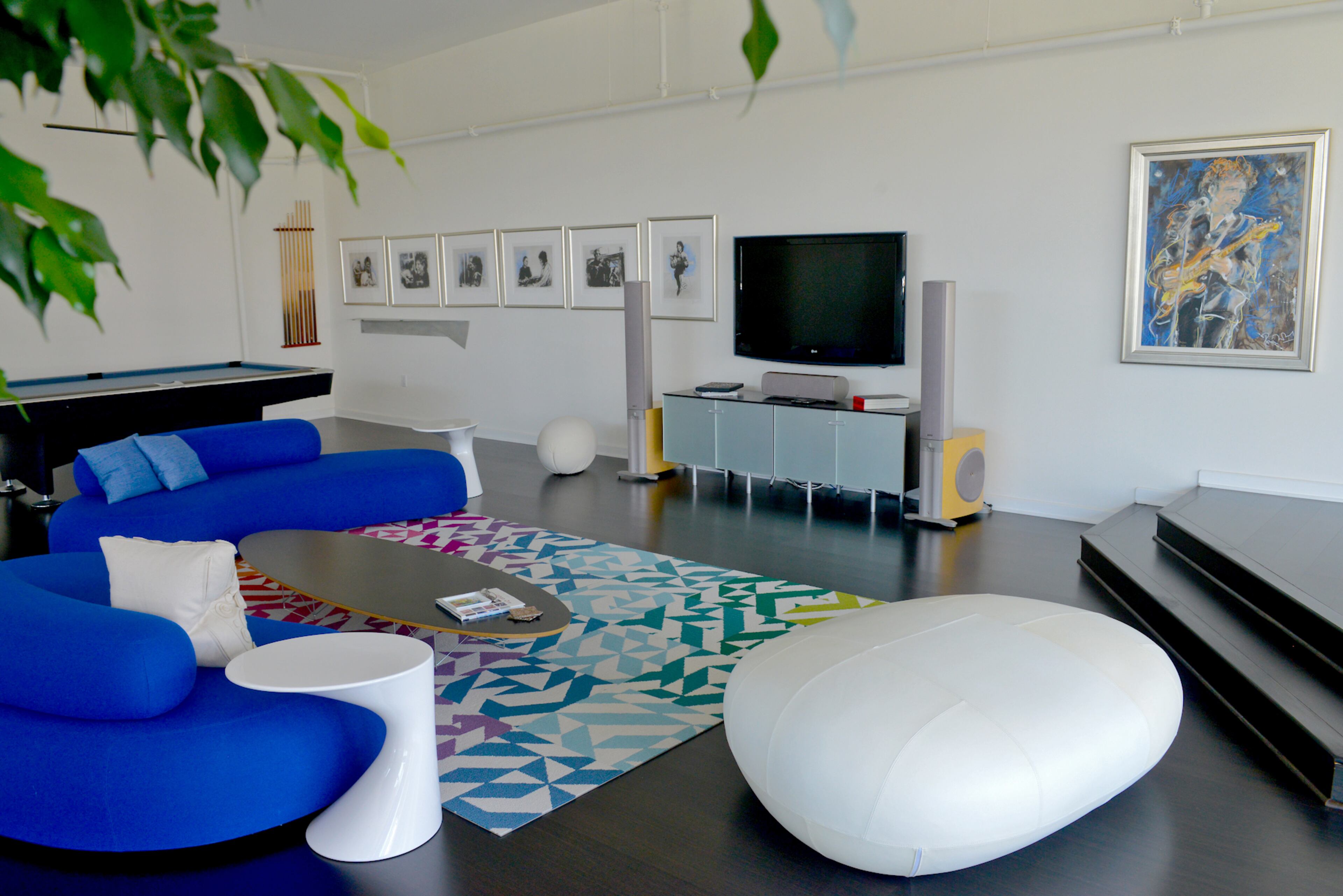 Bright blue sofas add a pop of color and dimension to David and Cindi Oakey's upstairs loft, while vivid carpet tiles from Flor help define a comfortable place to watch television in the vast multi-functional space.--Text by Lori Johnston and Keith Still/Fast Copy News Service