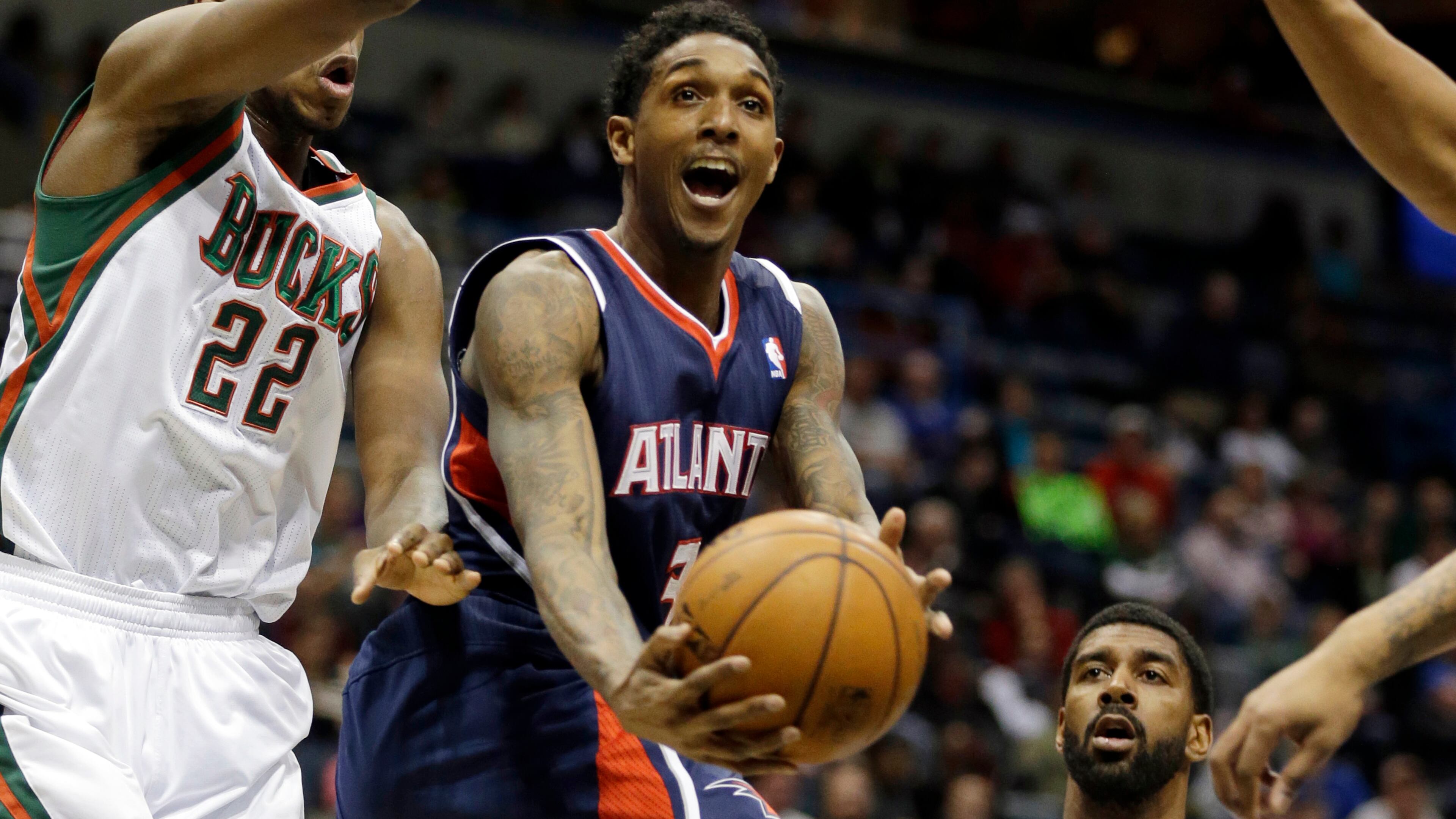 Atlanta Hawks' Louis Williams, middle, drives against Milwaukee Bucks' Khris Middleton (22) during the first half of an NBA basketball game Saturday, Jan. 25, 2014, in Milwaukee. (AP Photo/Jeffrey Phelps)