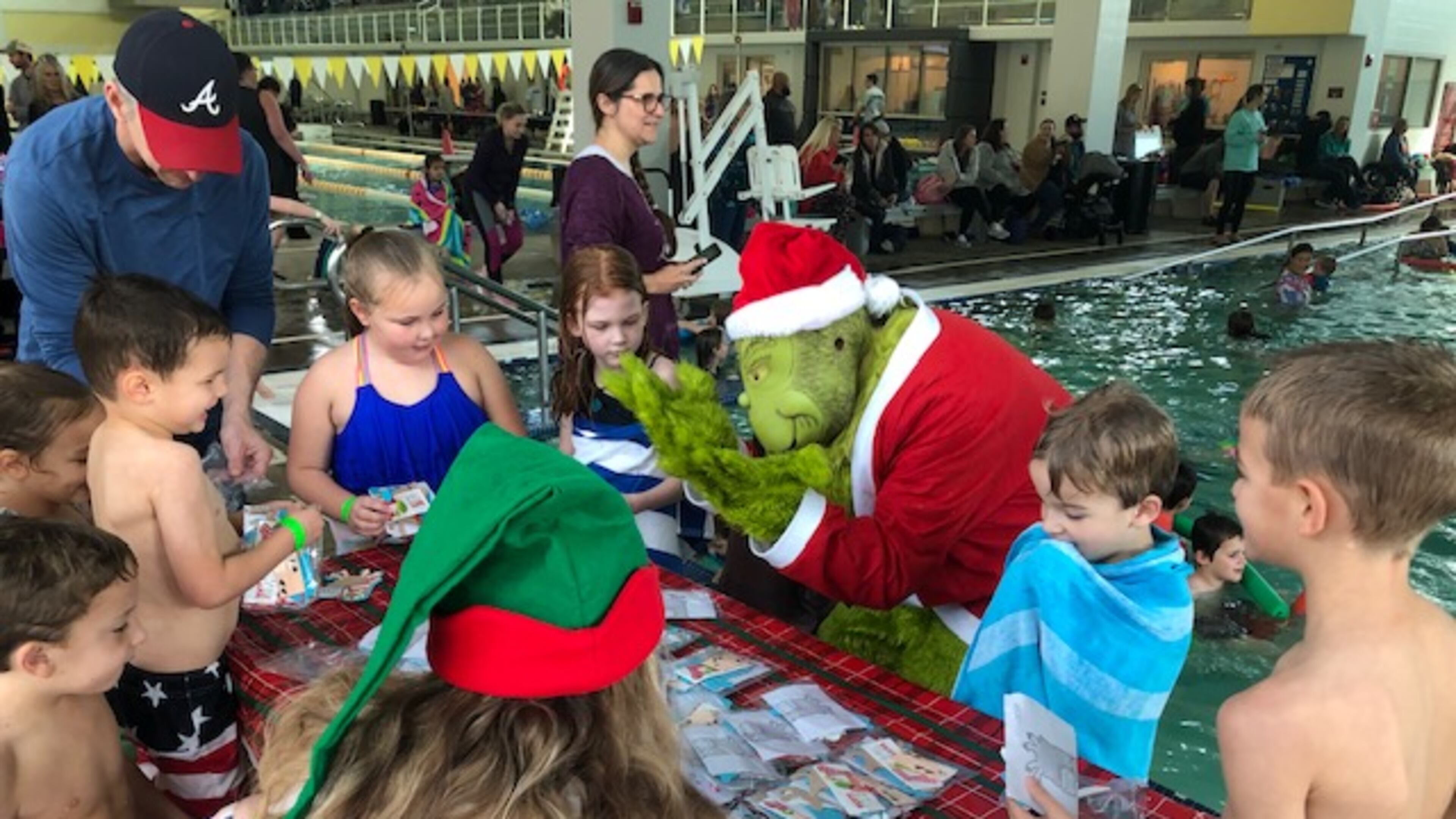 The Cherokee County Parks and Recreation Aquatic Center's 2019 last Grinch event before the pandemic. Shown is the Grinch helping with crafts but known for his mischief, he disrupted some of the kids during craft time.