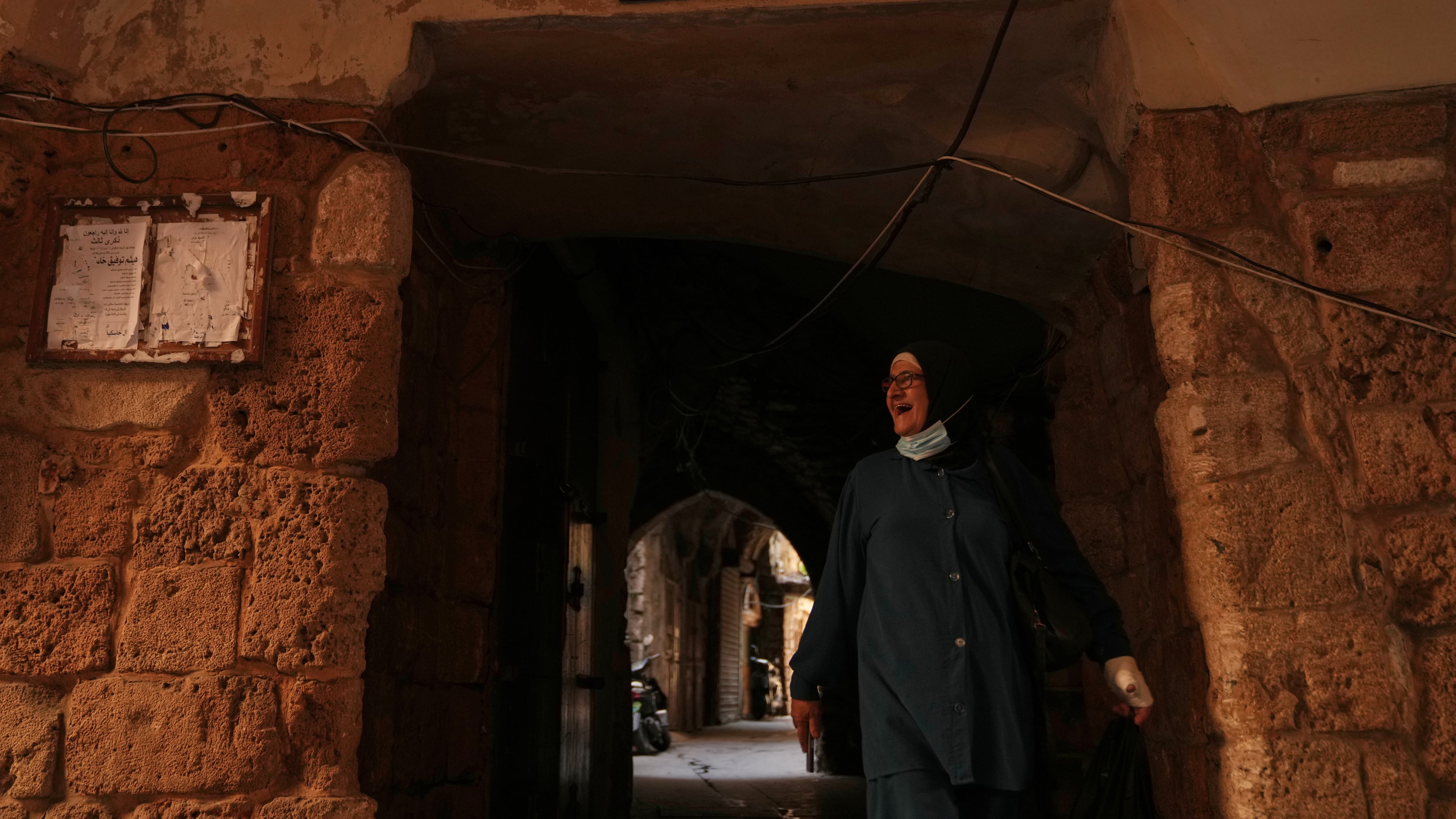 A woman walks beneath a sign that reads in Arabic "Jewish Quarter," in the old city of Sidon, southern Lebanon, Friday, Sept. 25, 2026. (AP Photo/Hassan Ammar)