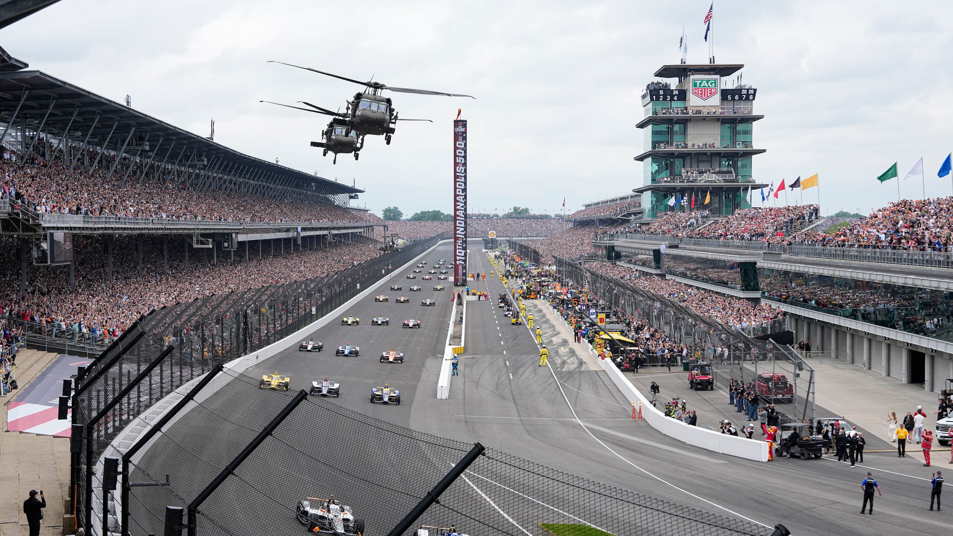 FILE - Helicopters fly over the field on the parade lap before the Indianapolis 500 auto race in Indianapolis, May 24, 2026. (AP Photo/Michael Conroy, File)