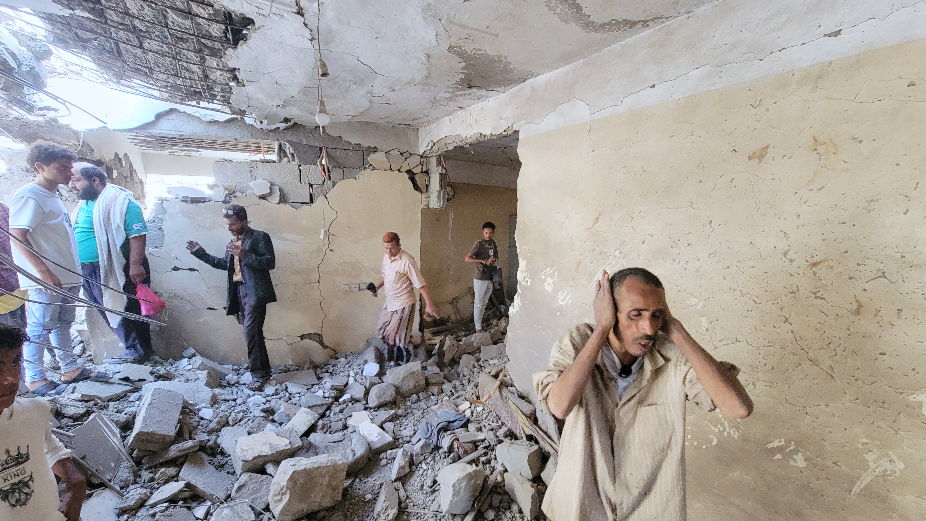 Residents walk on debris of their homes at Seina district in Taiz, Yemen, after a missile strike, Tuesday, Oct. 20, 2026. (AP Photo/Marzouq Al Jabri)