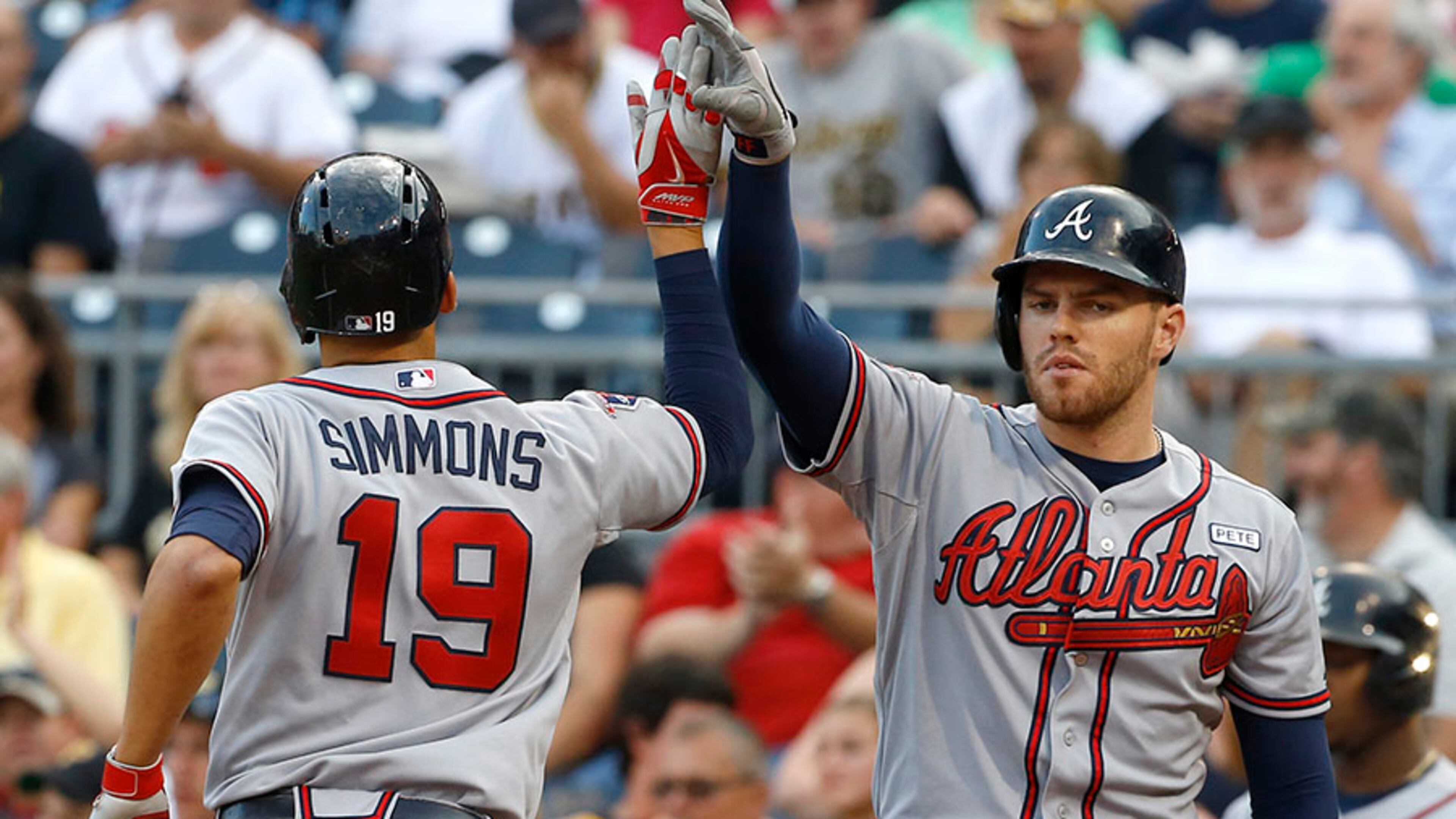 Atlanta Braves' Andrelton Simmons is greeted by on-deck batter Freddie Freeman after hitting a solo home run in the first inning of the Braves' 7-3 in over the Pirates Monday, Aug. 18, 2014, in Pittsburgh.