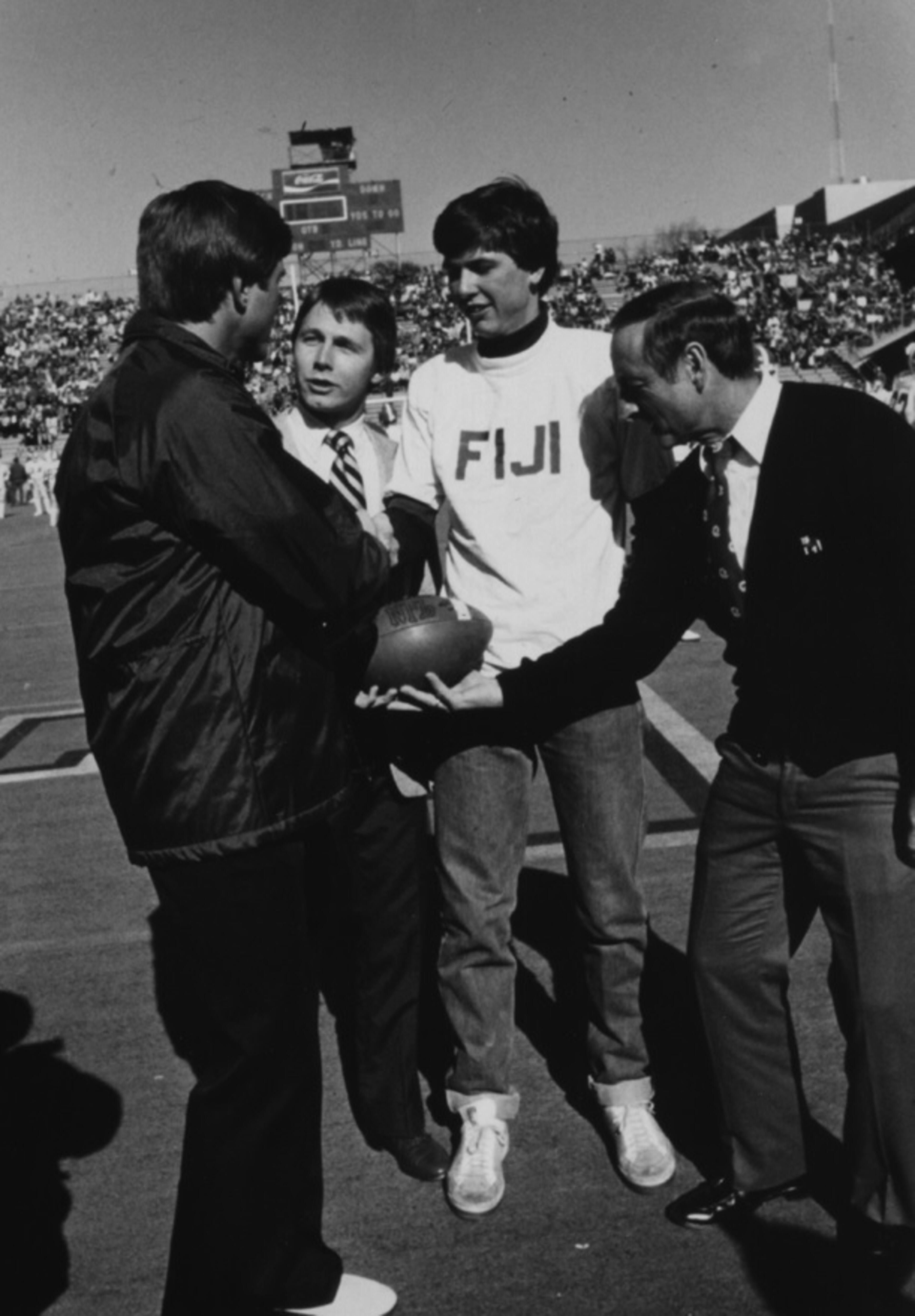 At the 1981 Georgia-Georgia Tech game, Yellow Jackets coach Bill Curry (left) and Bulldogs coach Vince Dooley (right) greet fraternity brothers Mark Johnson and Mike Spears as part of a leukemia fund drive at Grant Field. (Georgia Tech Archives)