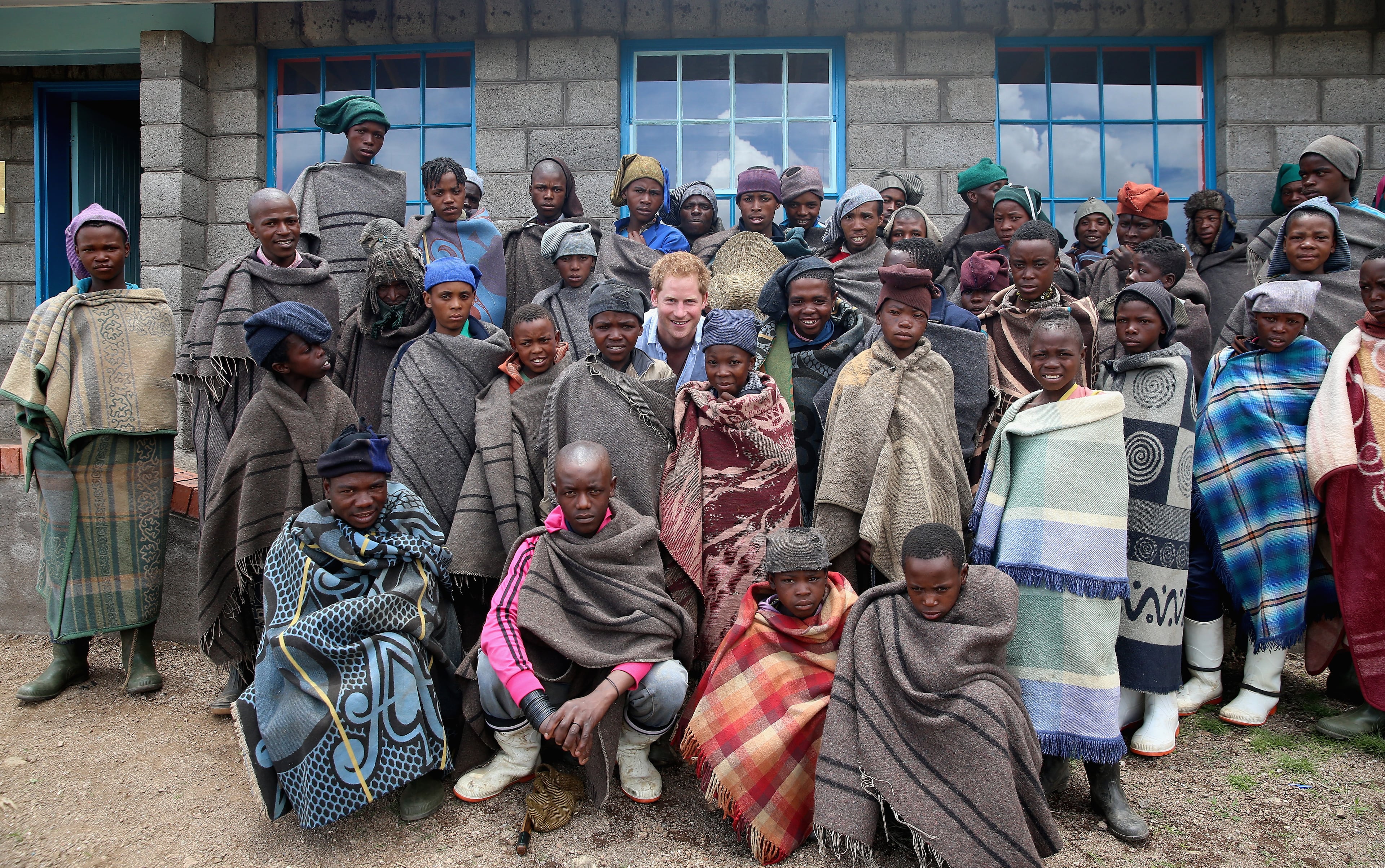 Prince Harry poses for a photograph with herd boys during a visit to a herd boy night school constructed by Sentebale on December 8, 2014 in Mokhotlong, Lesotho. Prince Harry was visiting Lesotho to see the work of his charity Sentebale. Sentebale provides healthcare and education to vulnerable children in Lesotho, Southern Africa. The particular theme of his visit was to check on the progress of the Mamohato Childrens Centre which will provide vital support to children affected by HIV. Prince Harry founded Sentebale (which means Forget Me Not in Sesotho) with Prince Seeiso in 2006. (Photo by Chris Jackson/Getty Images for Sentebale)