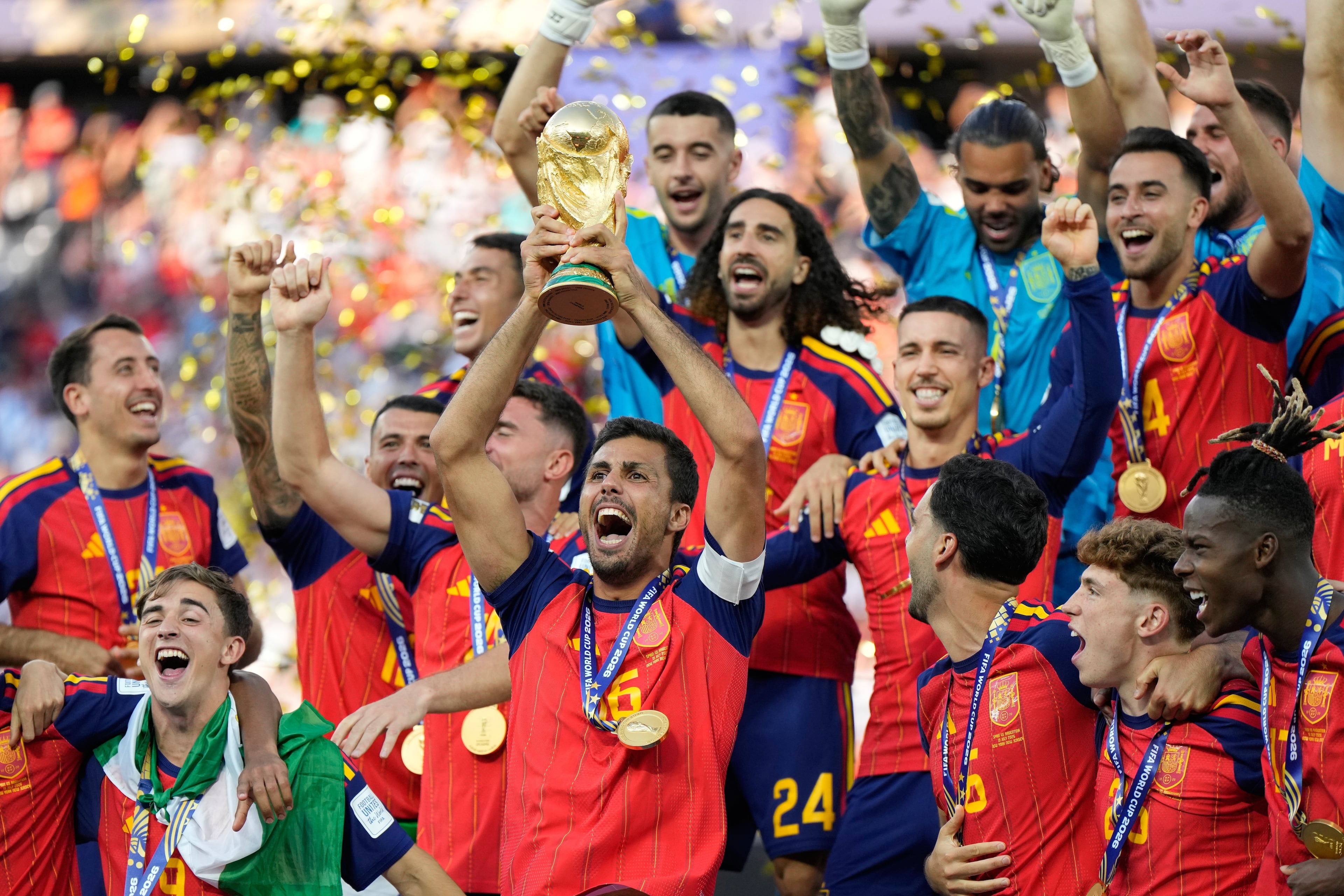 Spain's Rodri hoists the World Cup trophy surrounded by teammates. (Ashley Landis/AP)