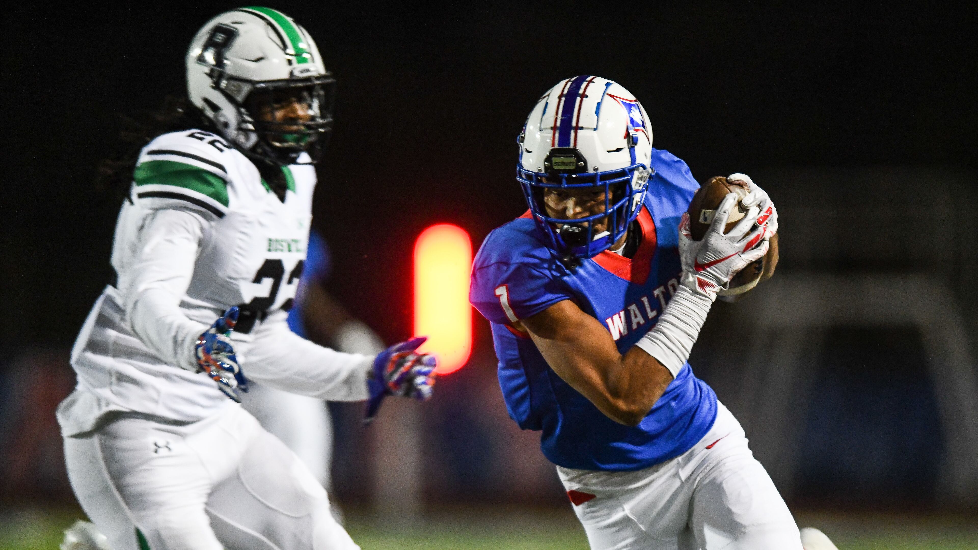 Walton's Dominick Blaylock (1) catches a pass ahead of Roswell's Tyron Hopper (22) Friday, Oct. 19, 2018, in Marietta.