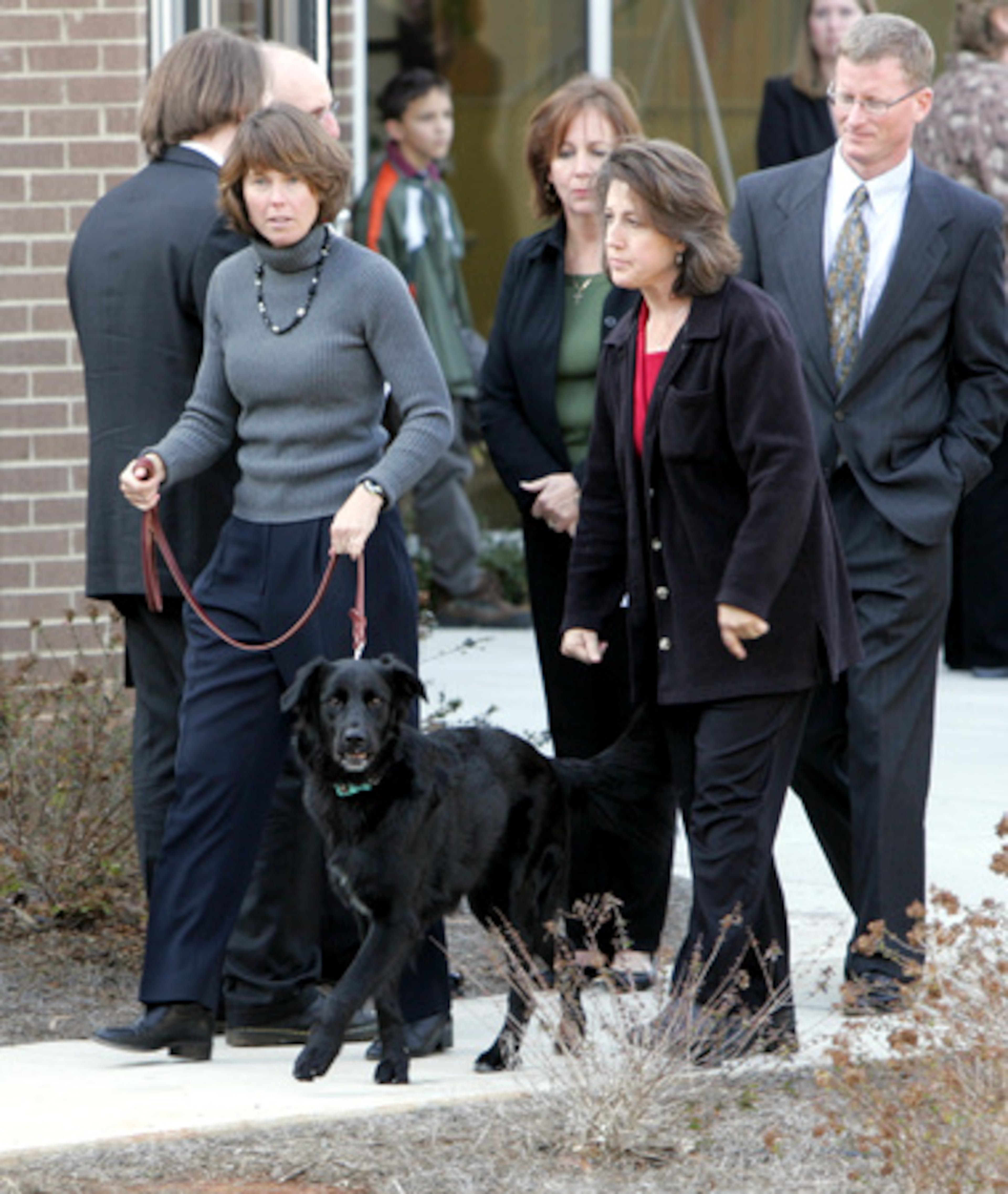 Meredith Emerson's dog, Ella, is walked by a family friend outside the church.